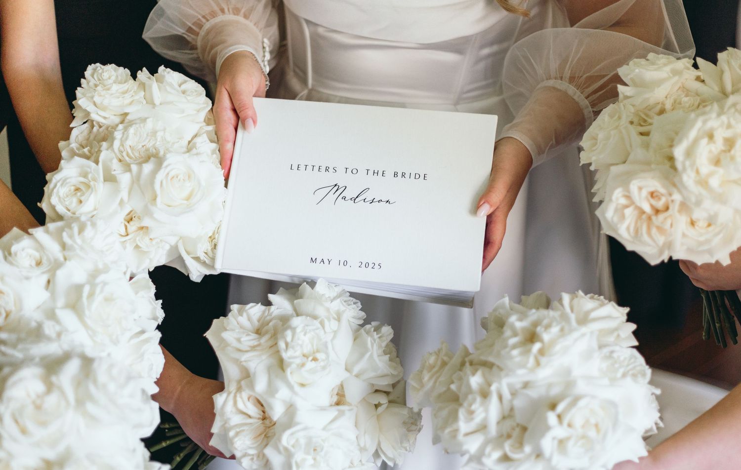 White hydrangea bouquet and wedding stationery displayed on white surface.