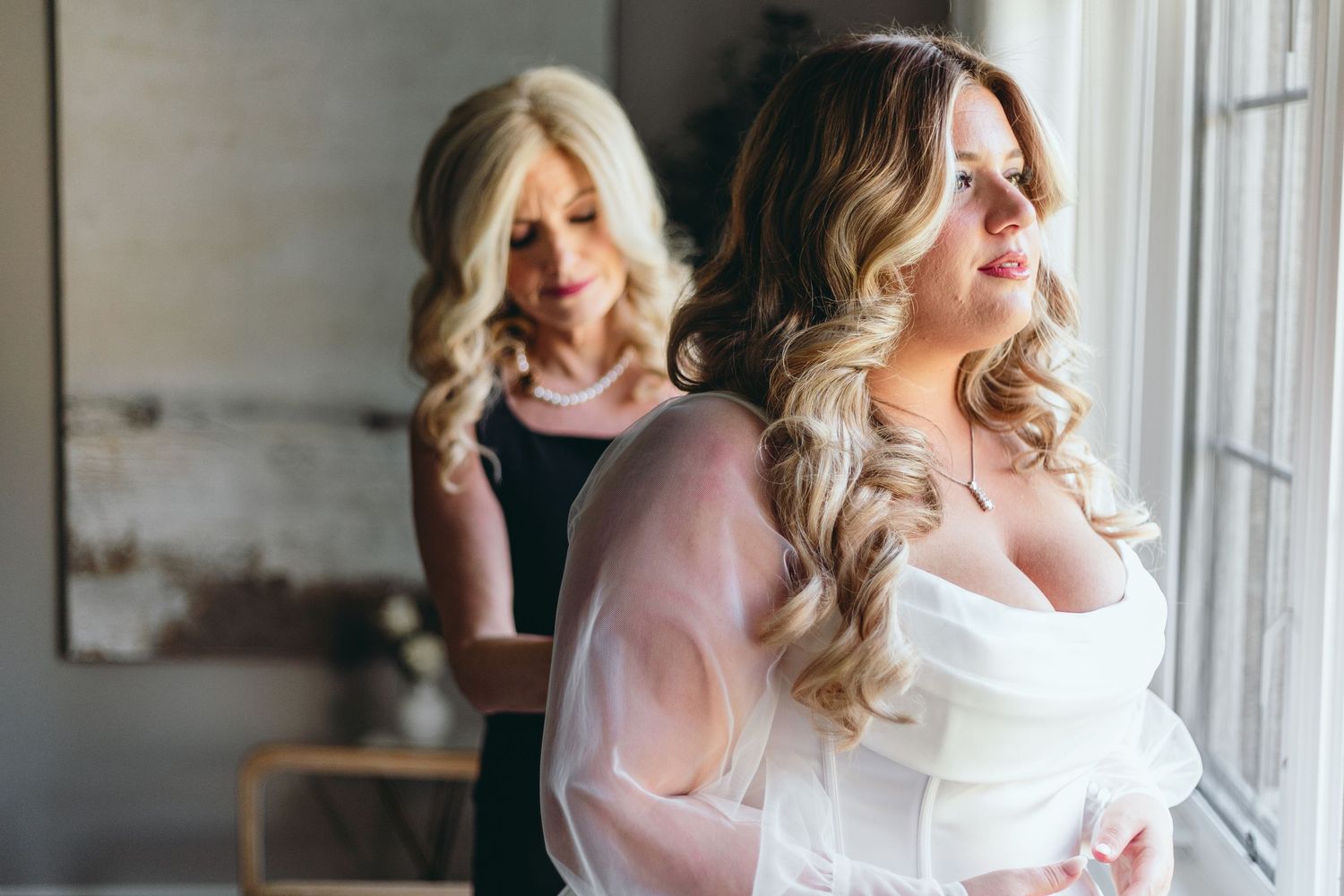 Natural light streams through windows during intimate wedding preparation moments.