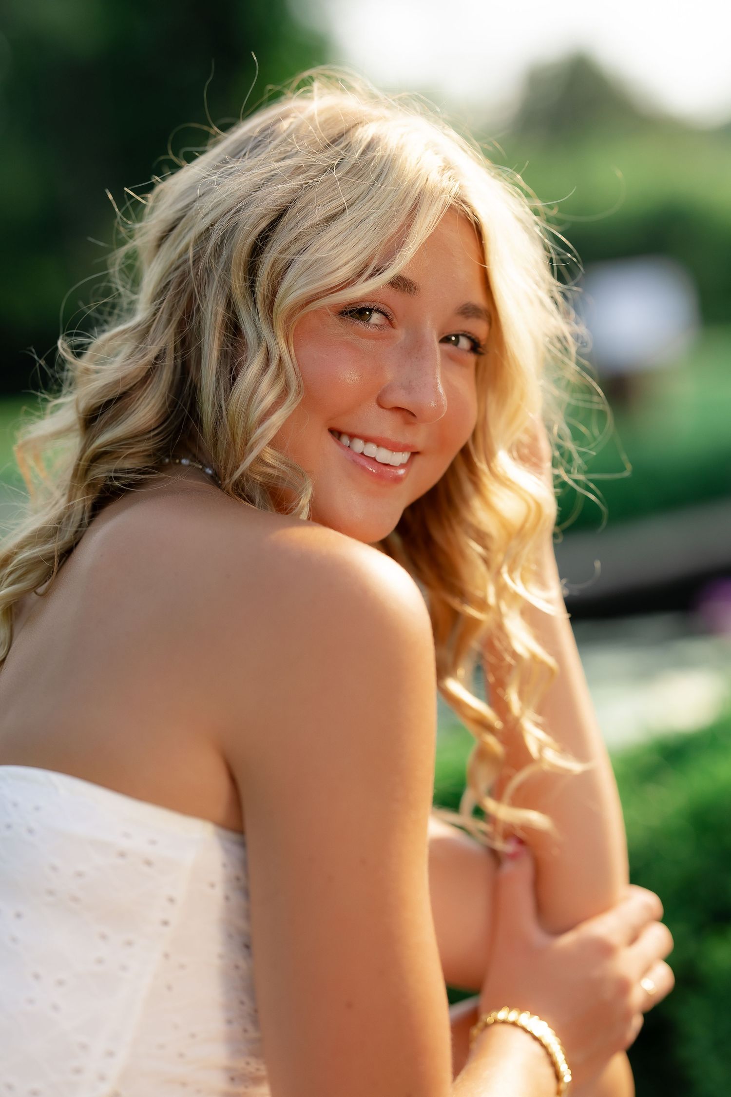 A series of connected photos showing a person with blonde hair in a white dress smiling and posing outdoors.