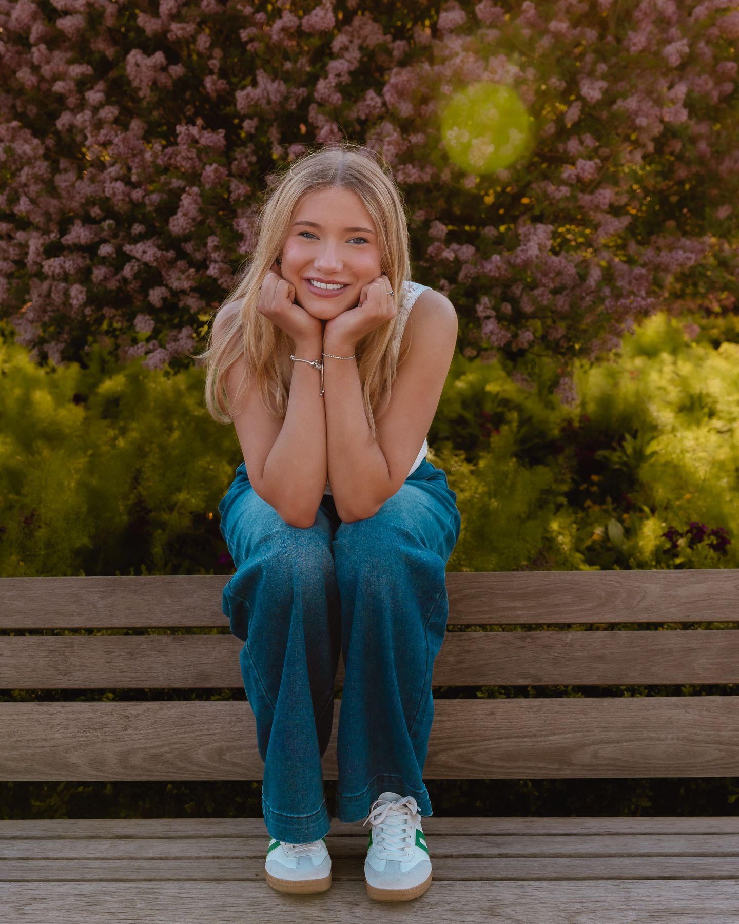 Senior sitting on a garden bench smiling in front of blooming flowers at Cantigny
