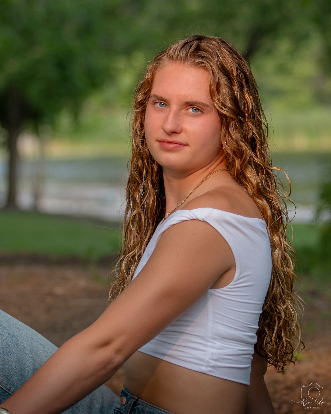 Athletic portrait session in a white crop top outdoors.