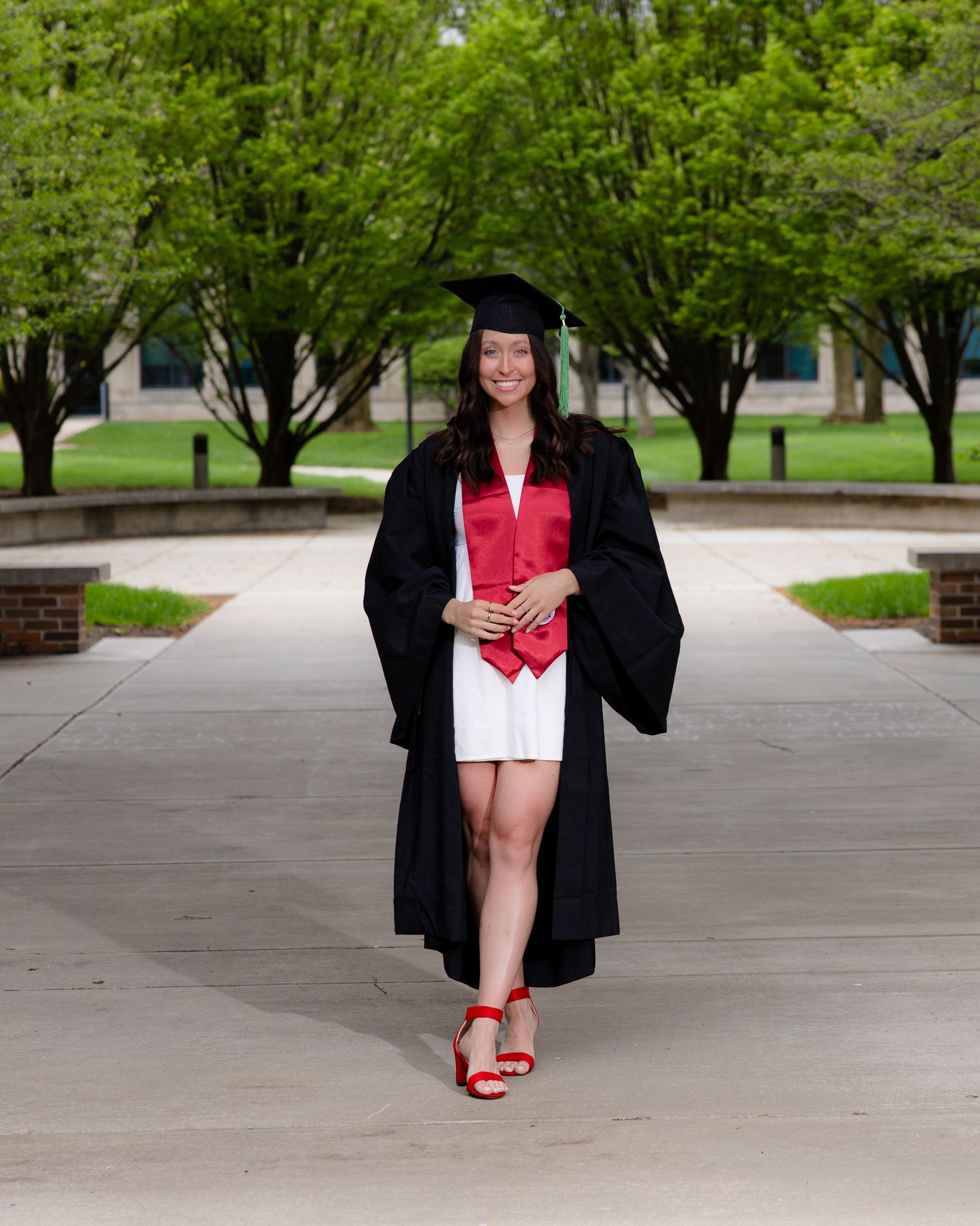 Graduation photos showing black cap and gown with red heels on campus walkway.