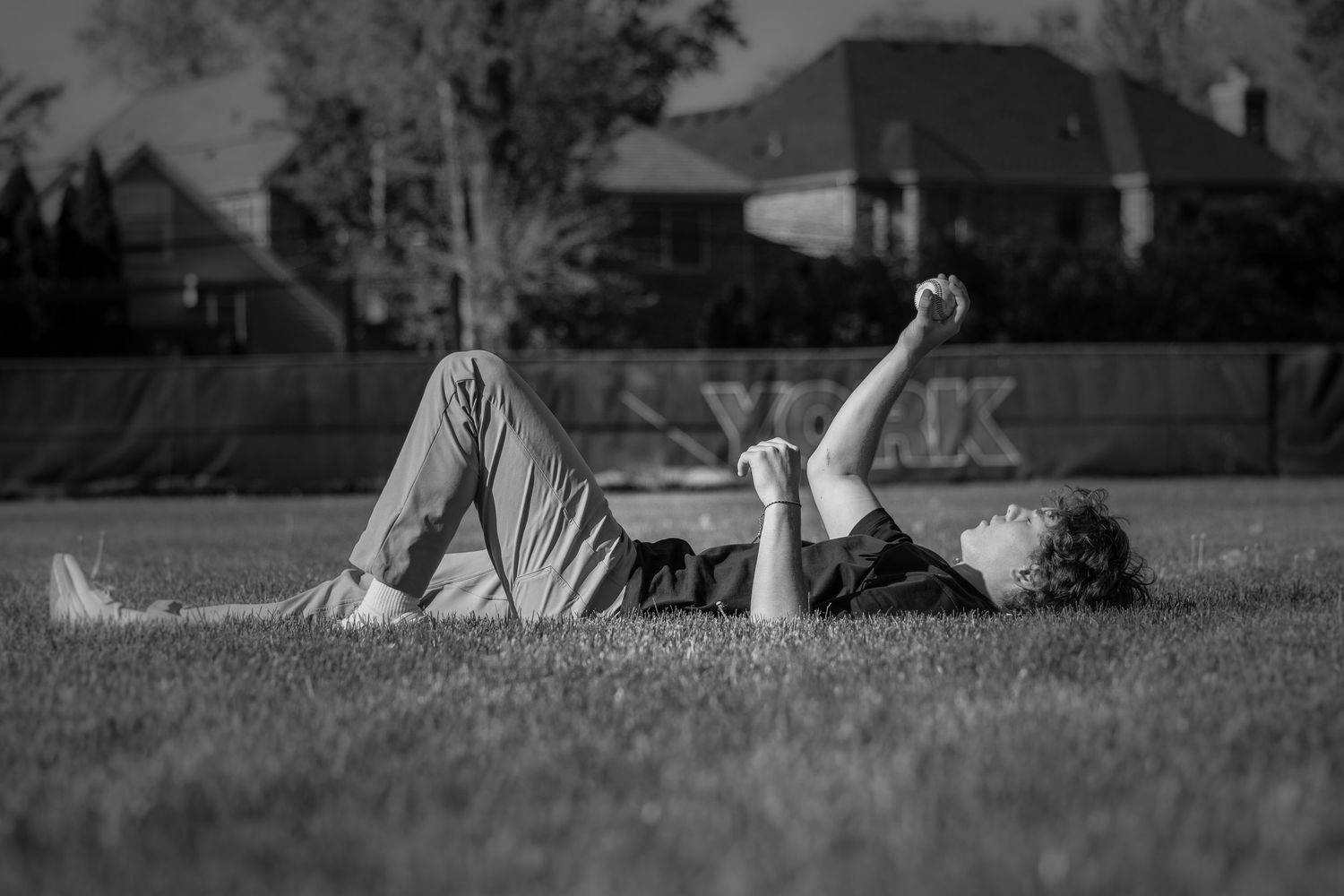 People relaxing on grass in a park on a sunny day captured in black and white.