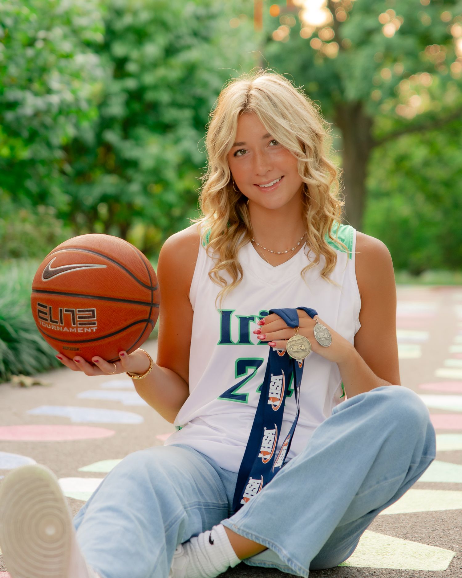 Basketball themed senior portraits with orange ball and varsity jersey.
