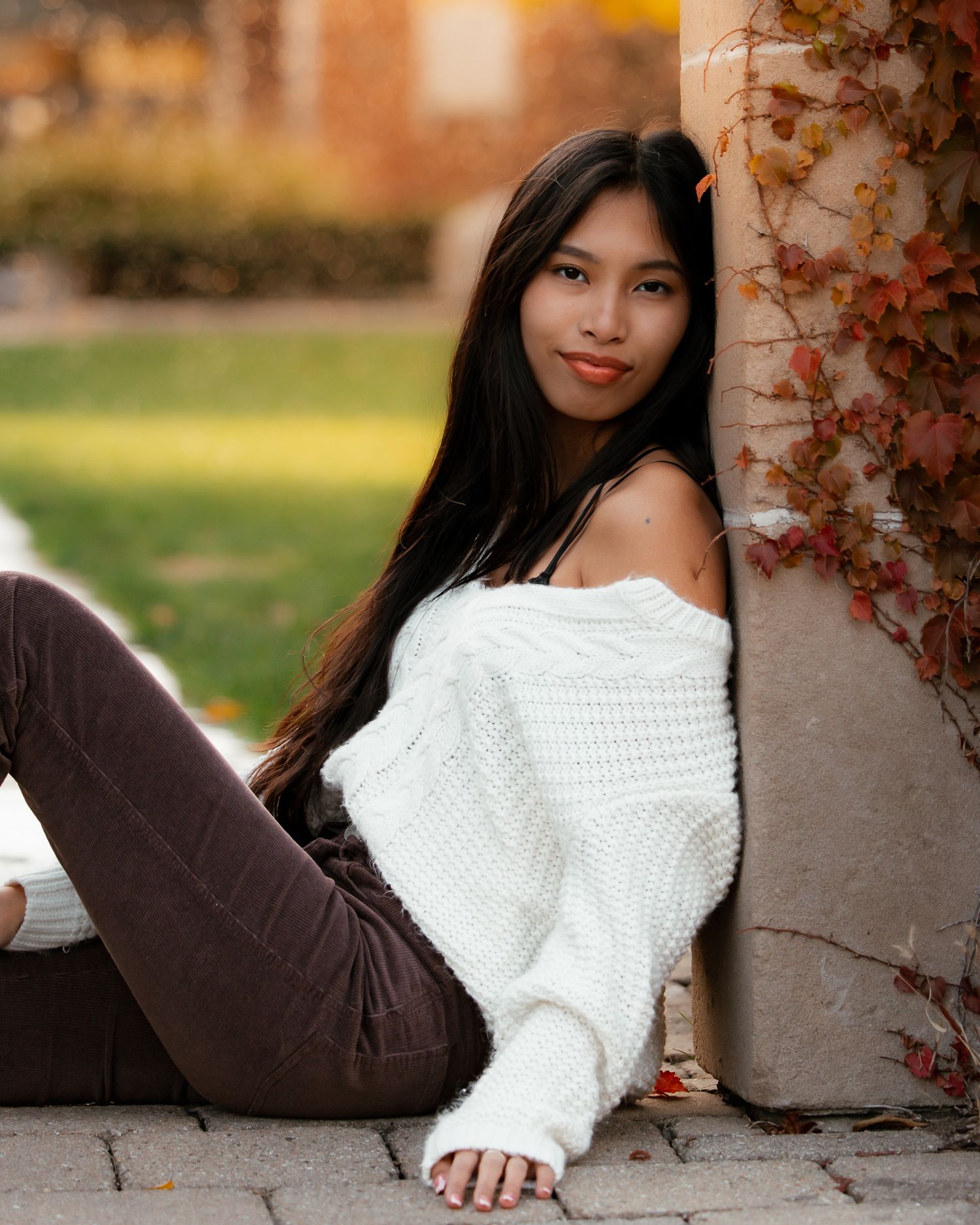 Artistic portrait series showing someone in a white sweater reclining against stone architecture.