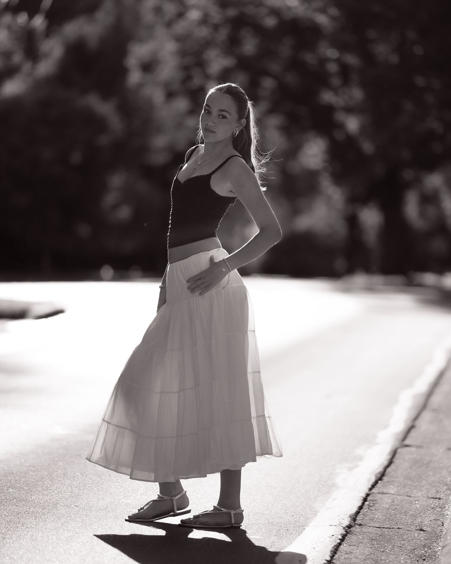 Black and white series capturing movement in flowing white dress outdoors.