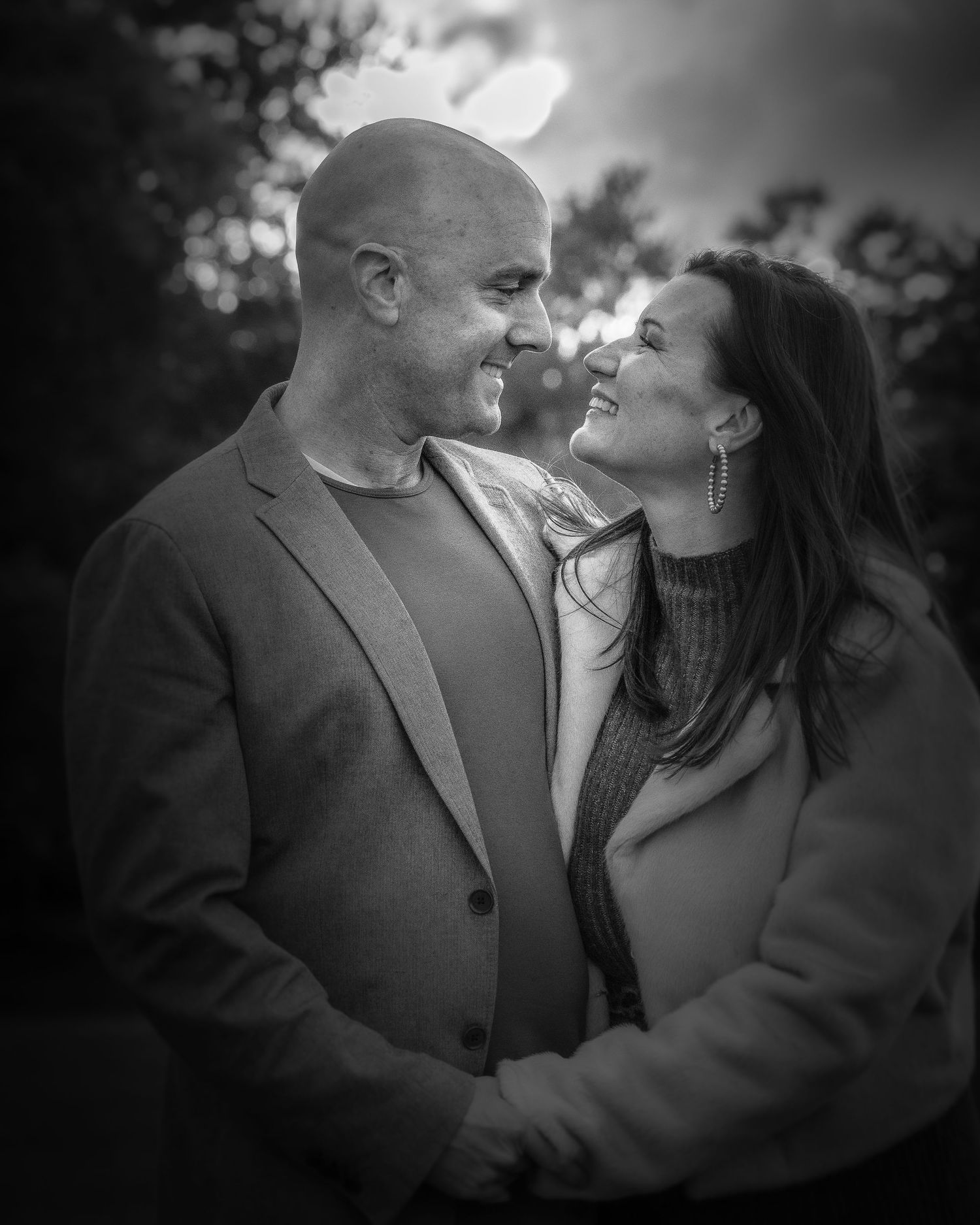 Romantic couple in cozy sweaters sharing tender moments outdoors.