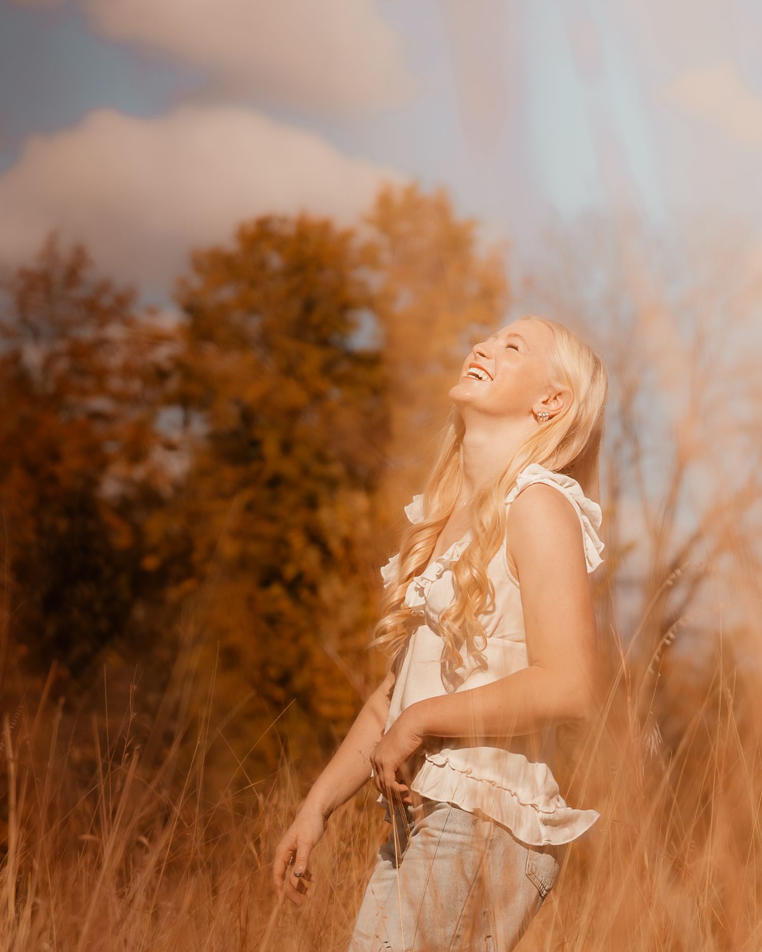 Candid shots of someone laughing in a field during sunset with warm autumn colors.