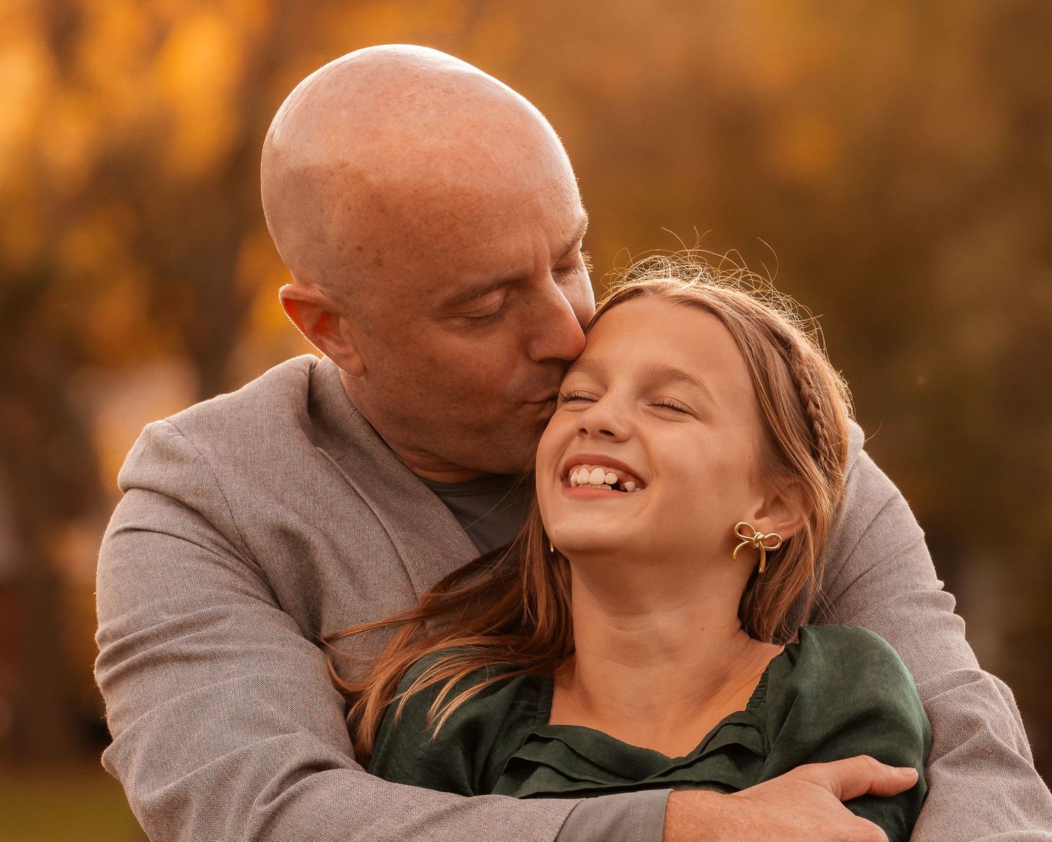 Couple shares intimate moments on grass during golden hour sunset photoshoot.