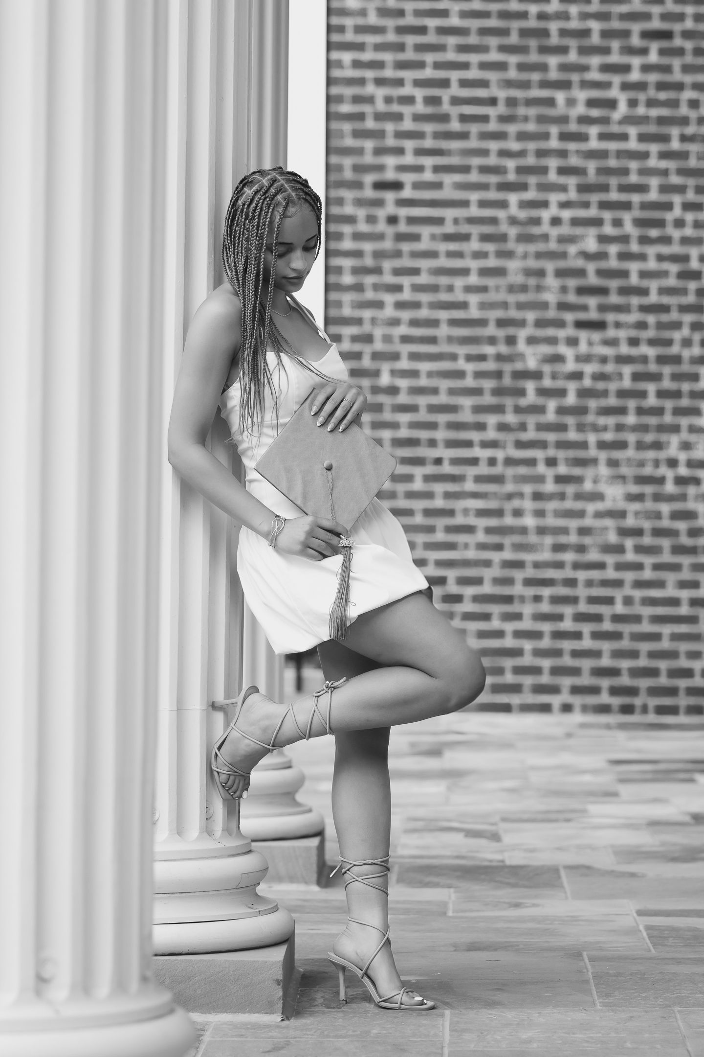 Fashion portraits against brick wall and white columns in black and white.