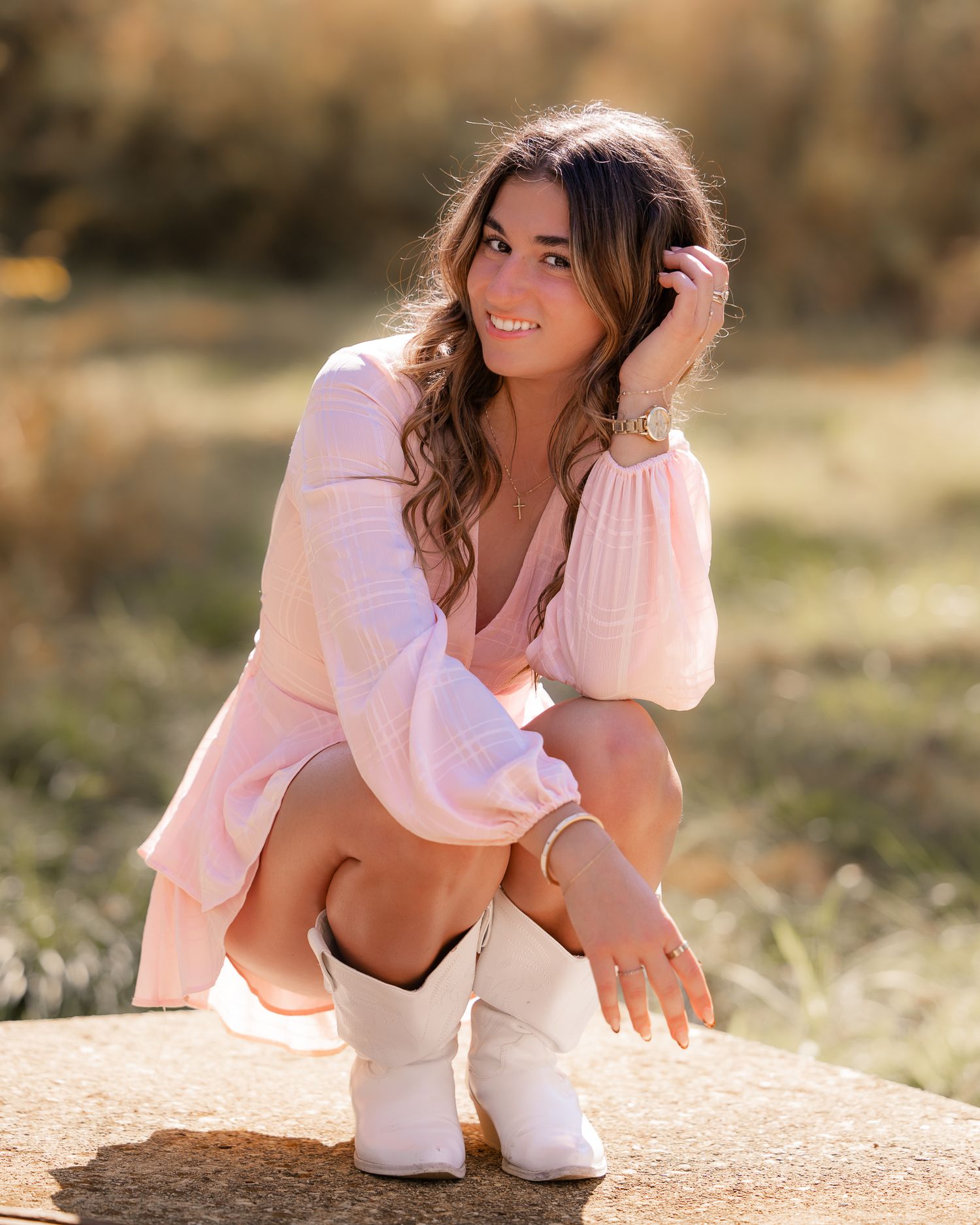 Woman in white cropped sweater posing outdoors in natural lighting.