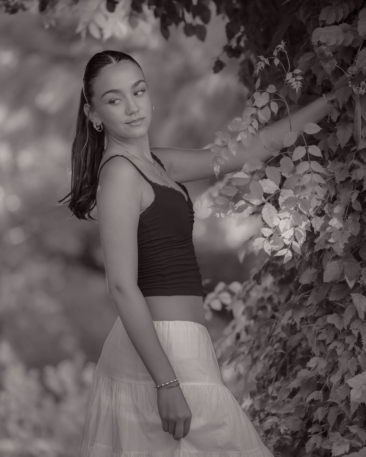 Black and white portrait series among blooming tree branches.