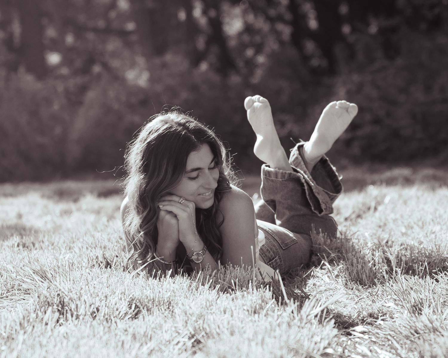 Black and white photo series of couple lying in grass field.