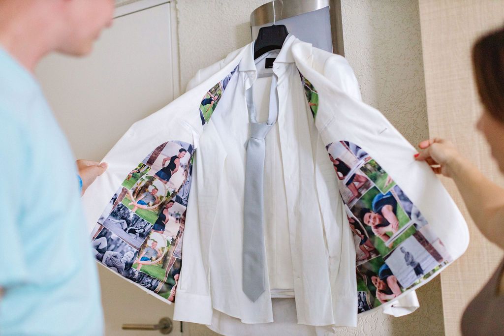 White wedding suit with colorful photo-printed lining hanging on a rack.