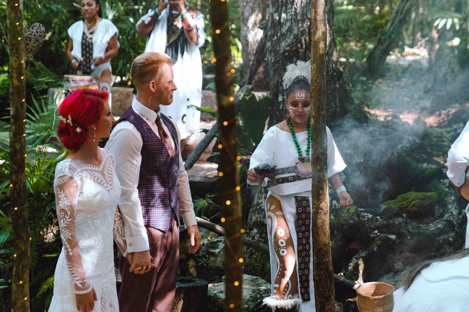 Bride and groom during a traditional Mayan wedding ceremony in a lush tropical jungle setting.