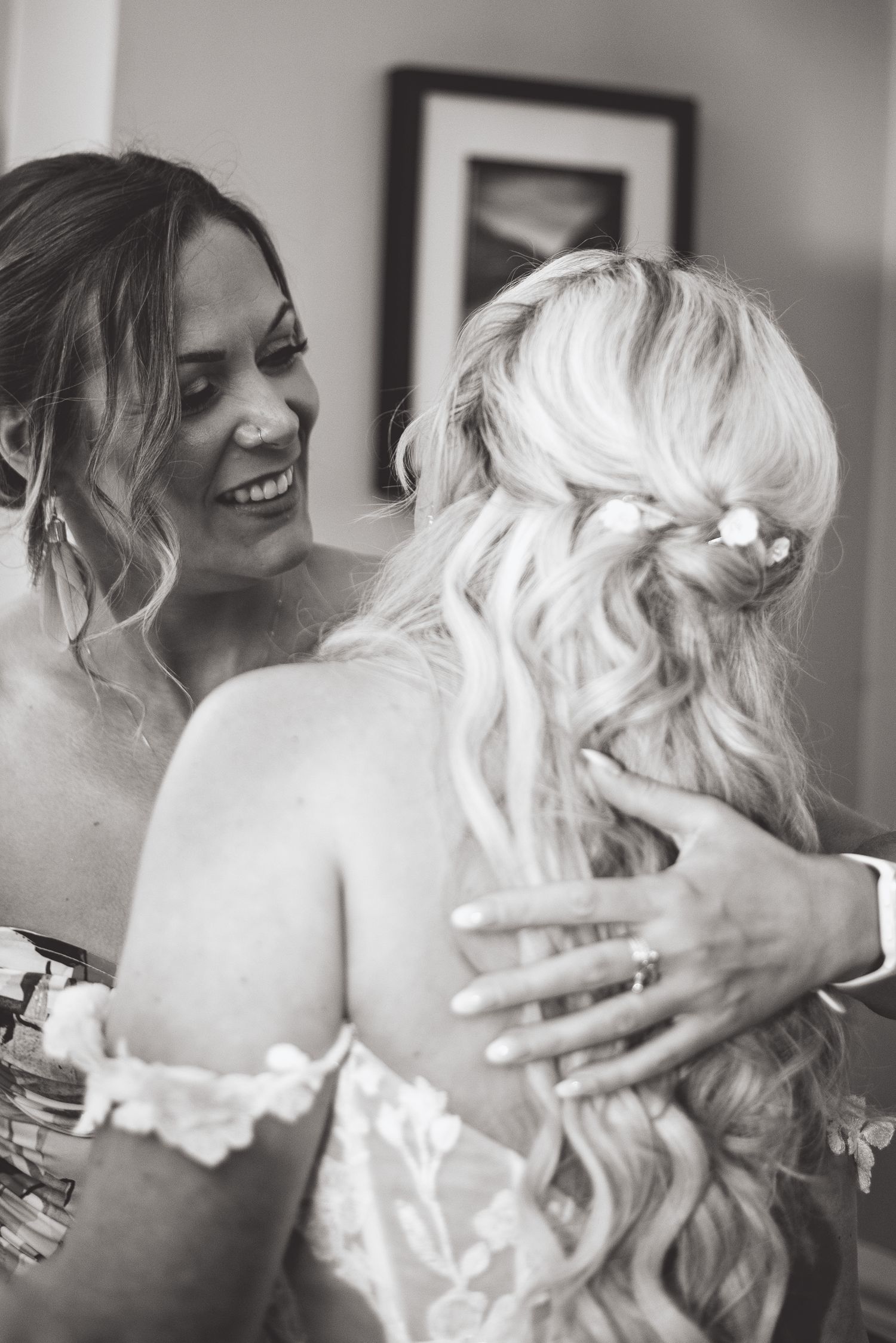 Black and white candid moment showing emotional embrace during wedding preparations.