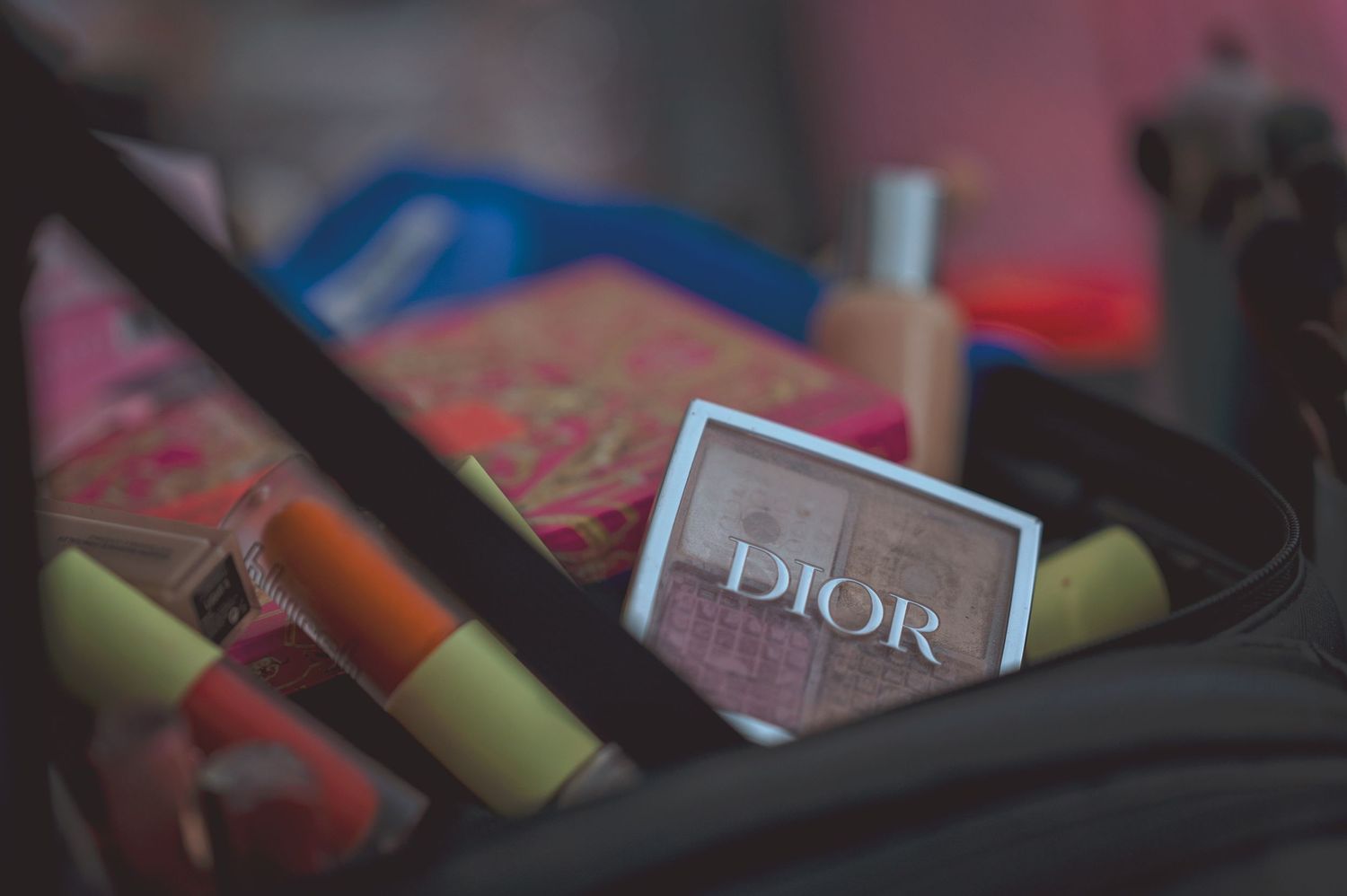 Dior makeup palette and cosmetics arranged in a bag for professional bridal beauty preparations.