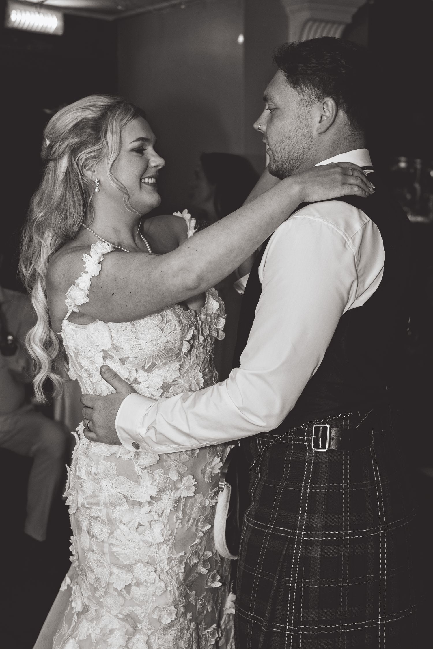 Couple shares romantic dance in traditional Scottish wedding attire with kilt.