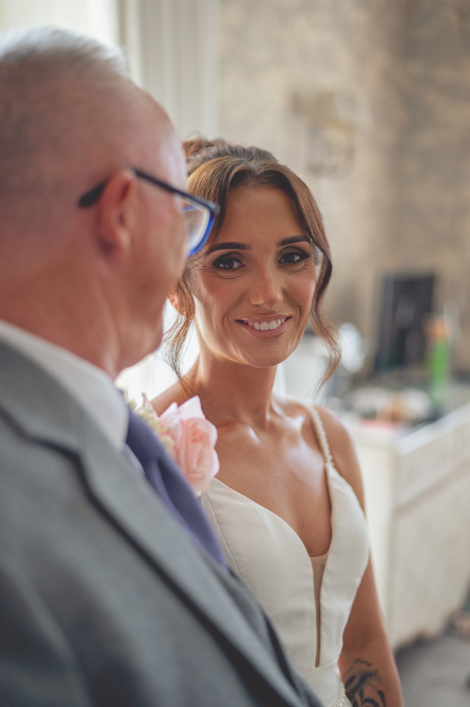 Candid moment between wedding attendees during indoor celebration.