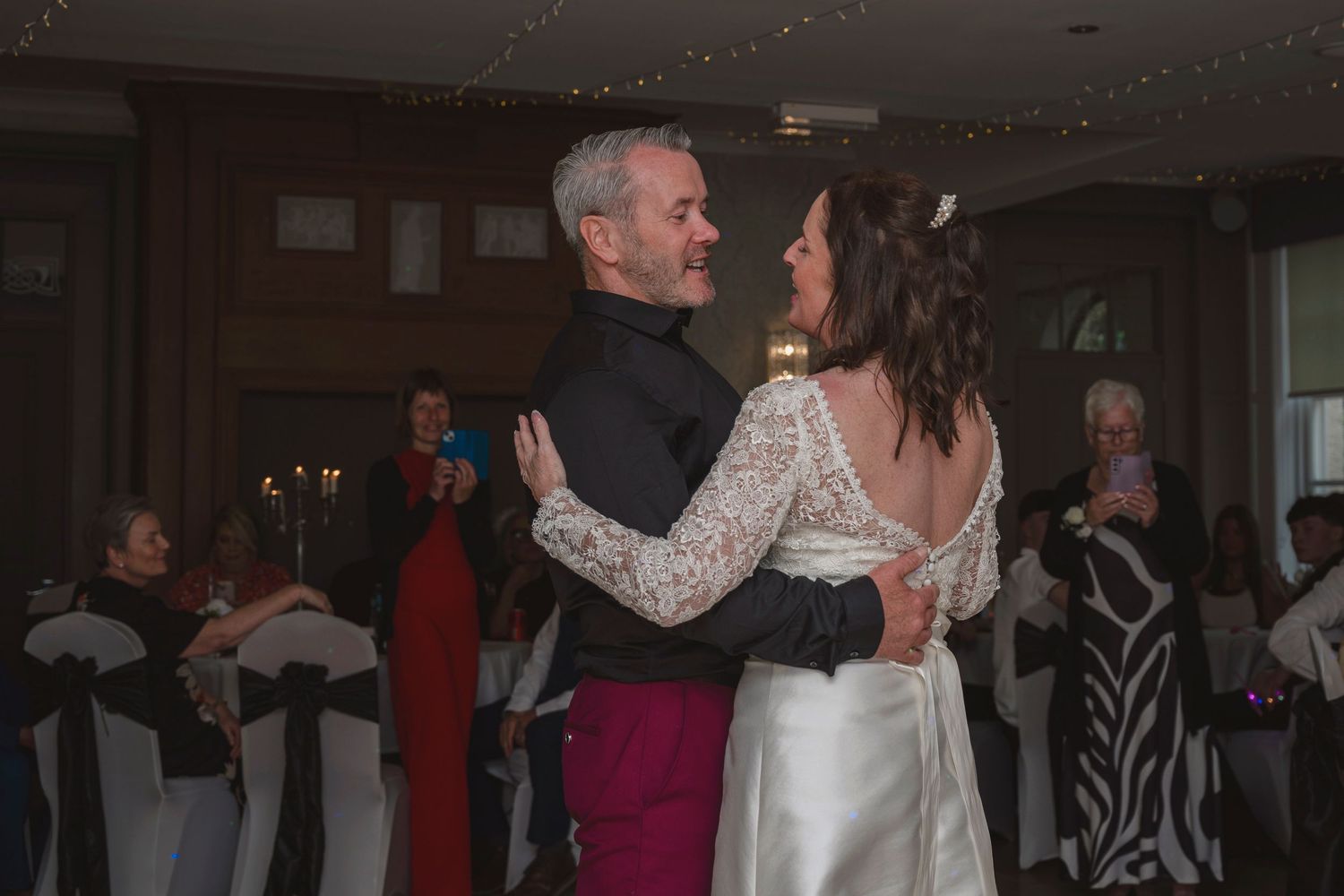 Bride and groom share their first dance at a wedding reception in an elegant venue.