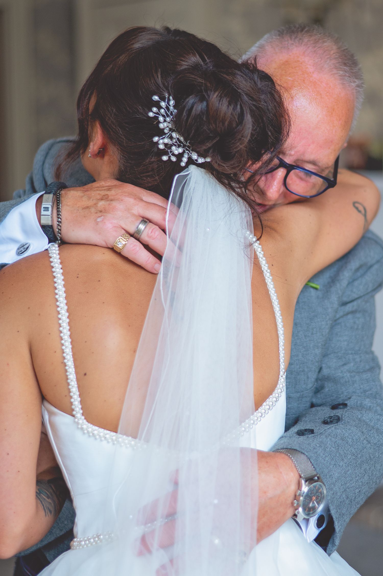 Close up view of a bride in white dress with pearl straps and veil.