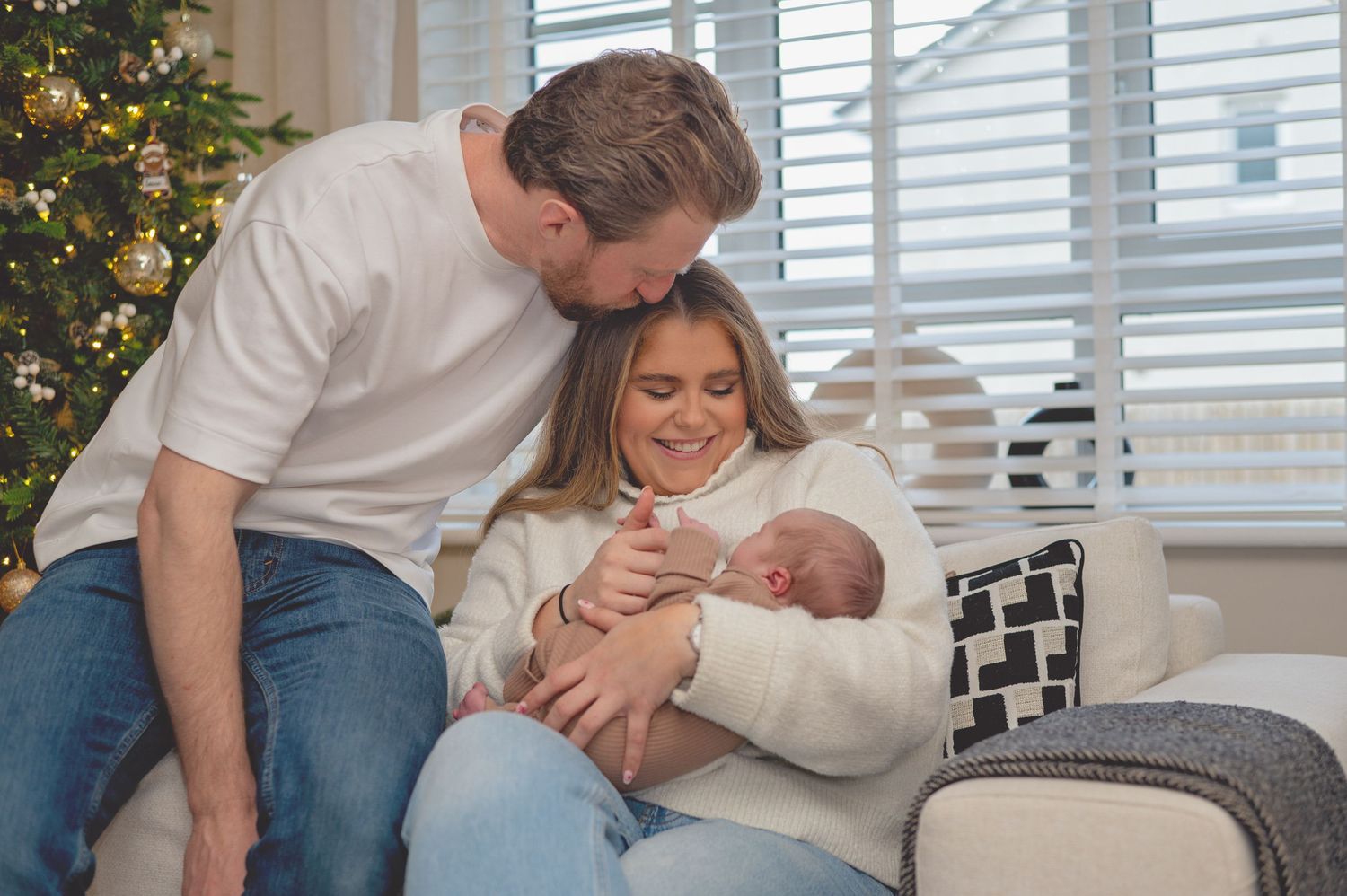 A series of tender moments between family members on a couch near a decorated Christmas tree.
