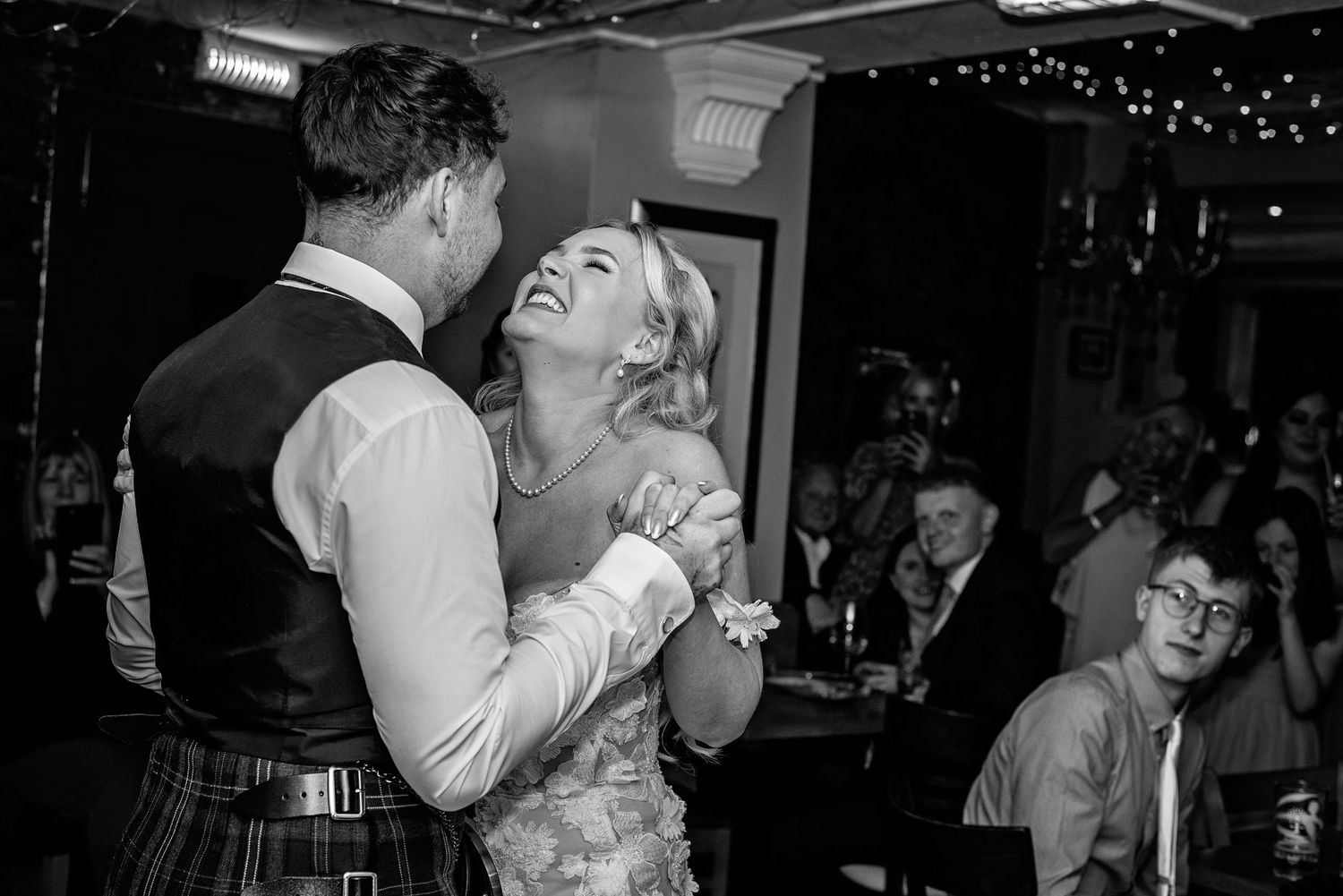 Black and white sequence captures joyful dancing moments at wedding reception.