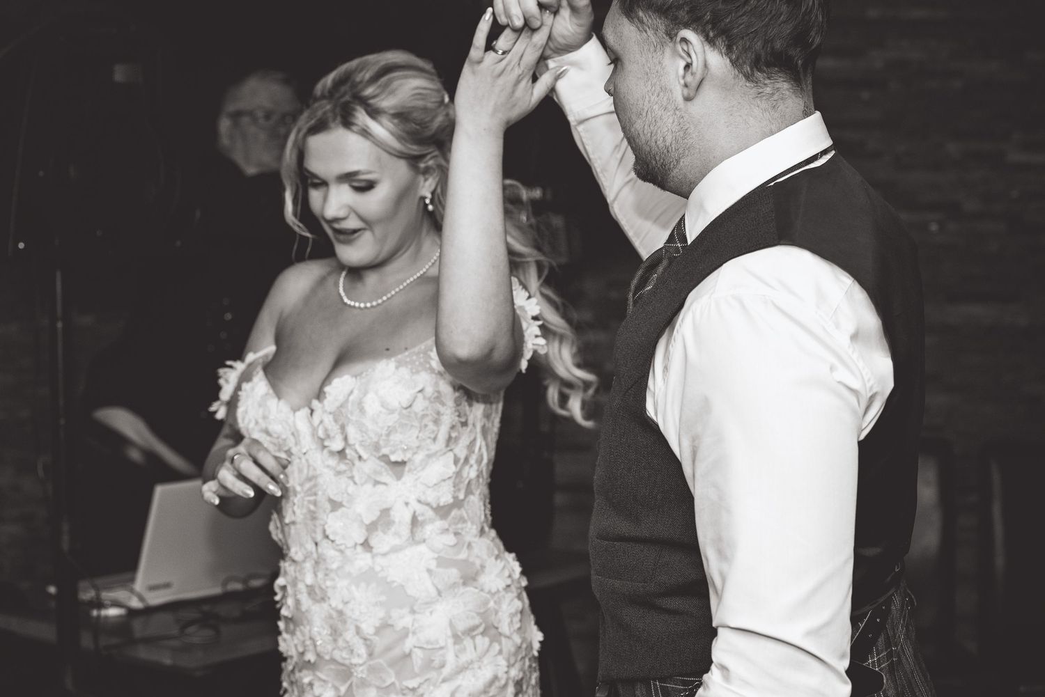 Couple dancing together at their wedding reception in formal attire.