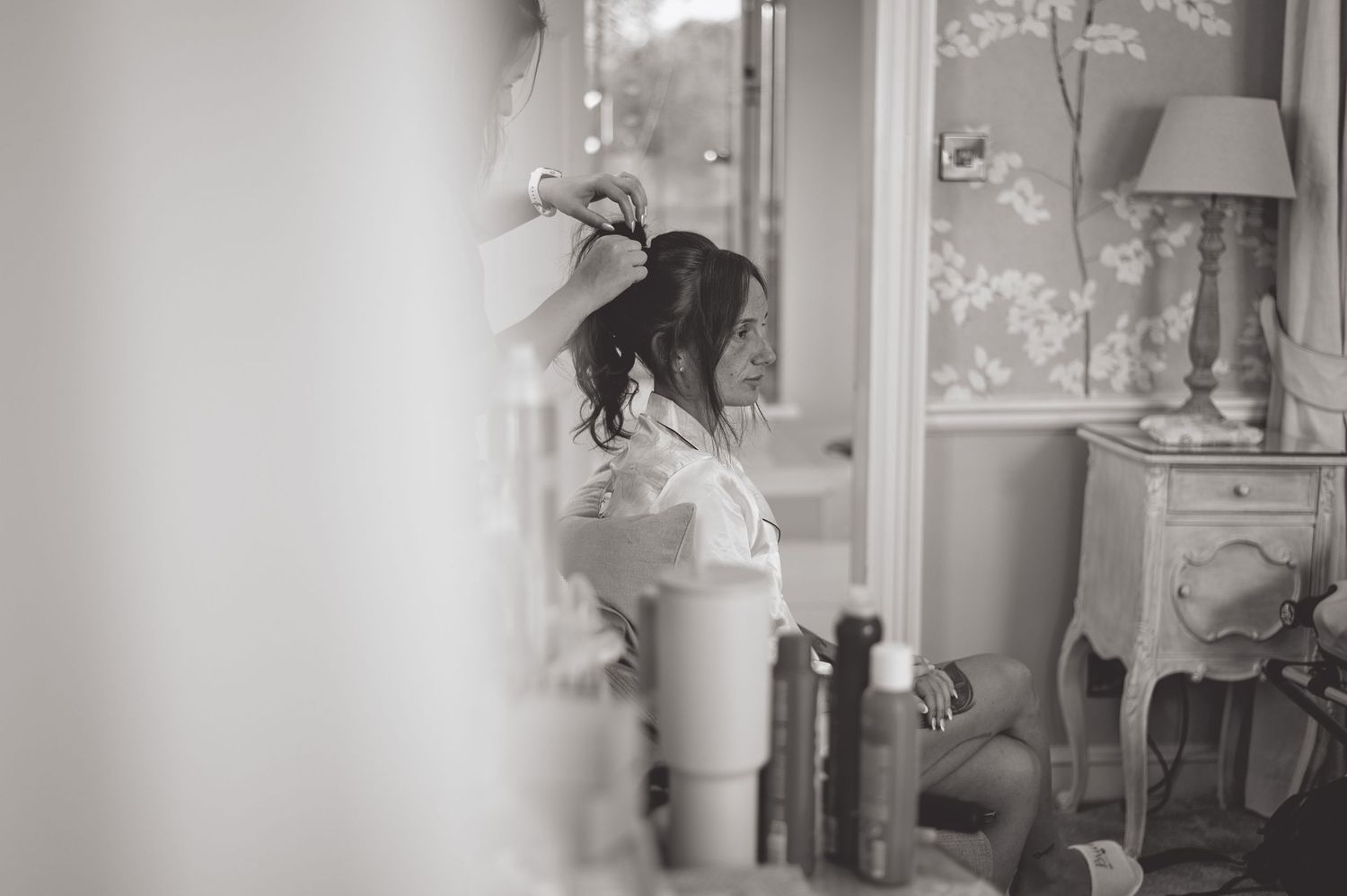 Soft focus black and white image of morning preparation through window reflection.