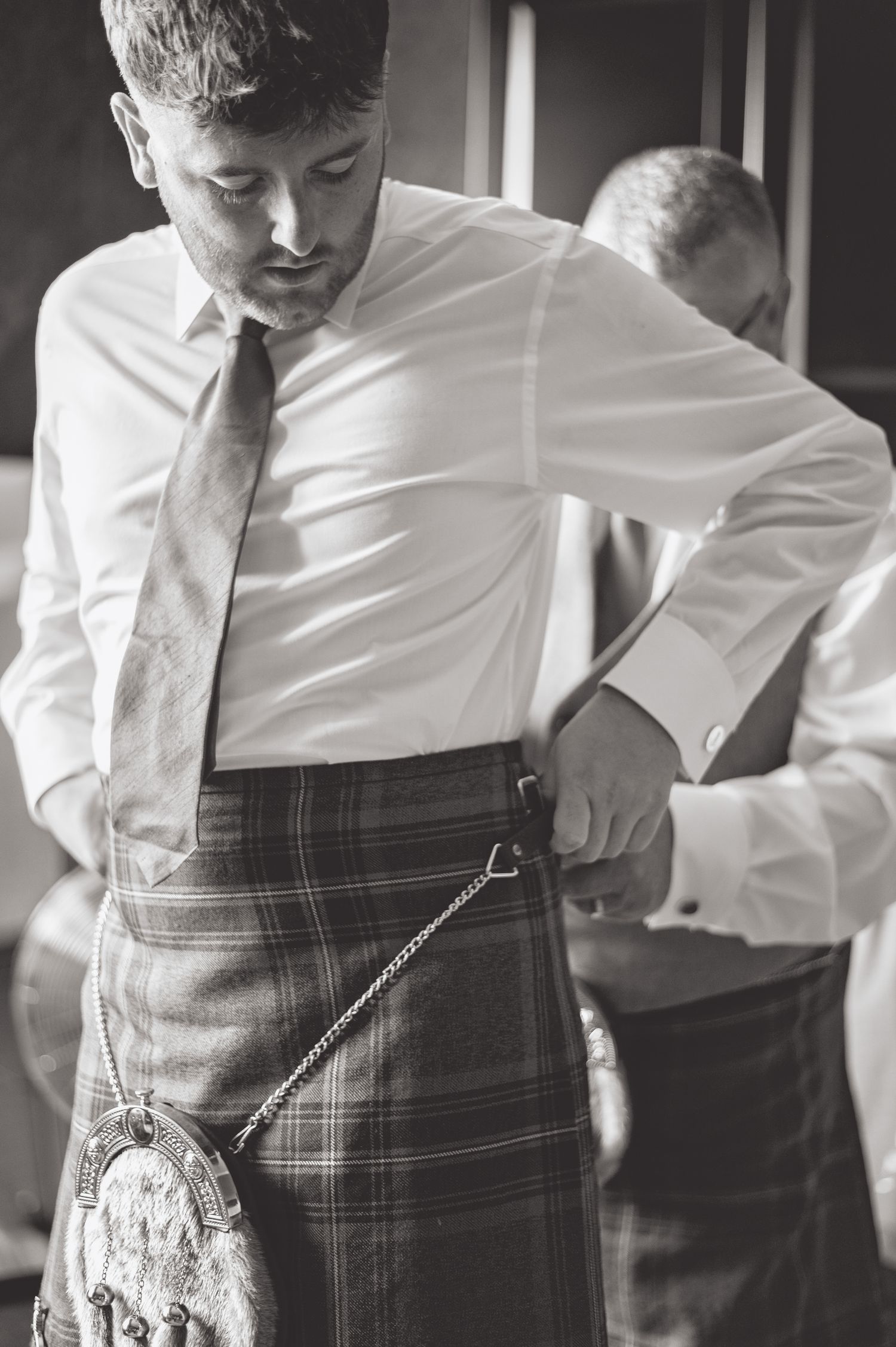 Close-up shots of traditional Scottish kilt attire being worn at a formal event.