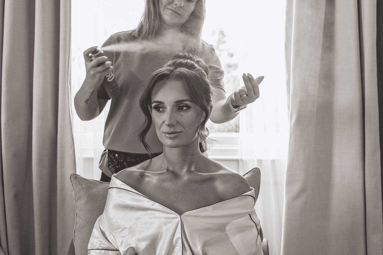 Wedding preparation scene with natural window lighting and elegant curtains.