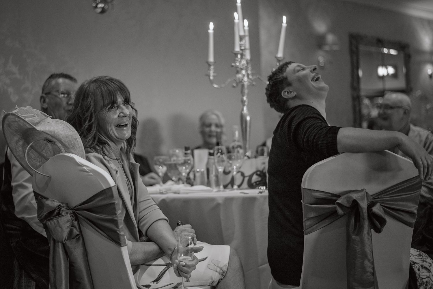 Black and white photo of wedding guests enjoying the reception celebration.
