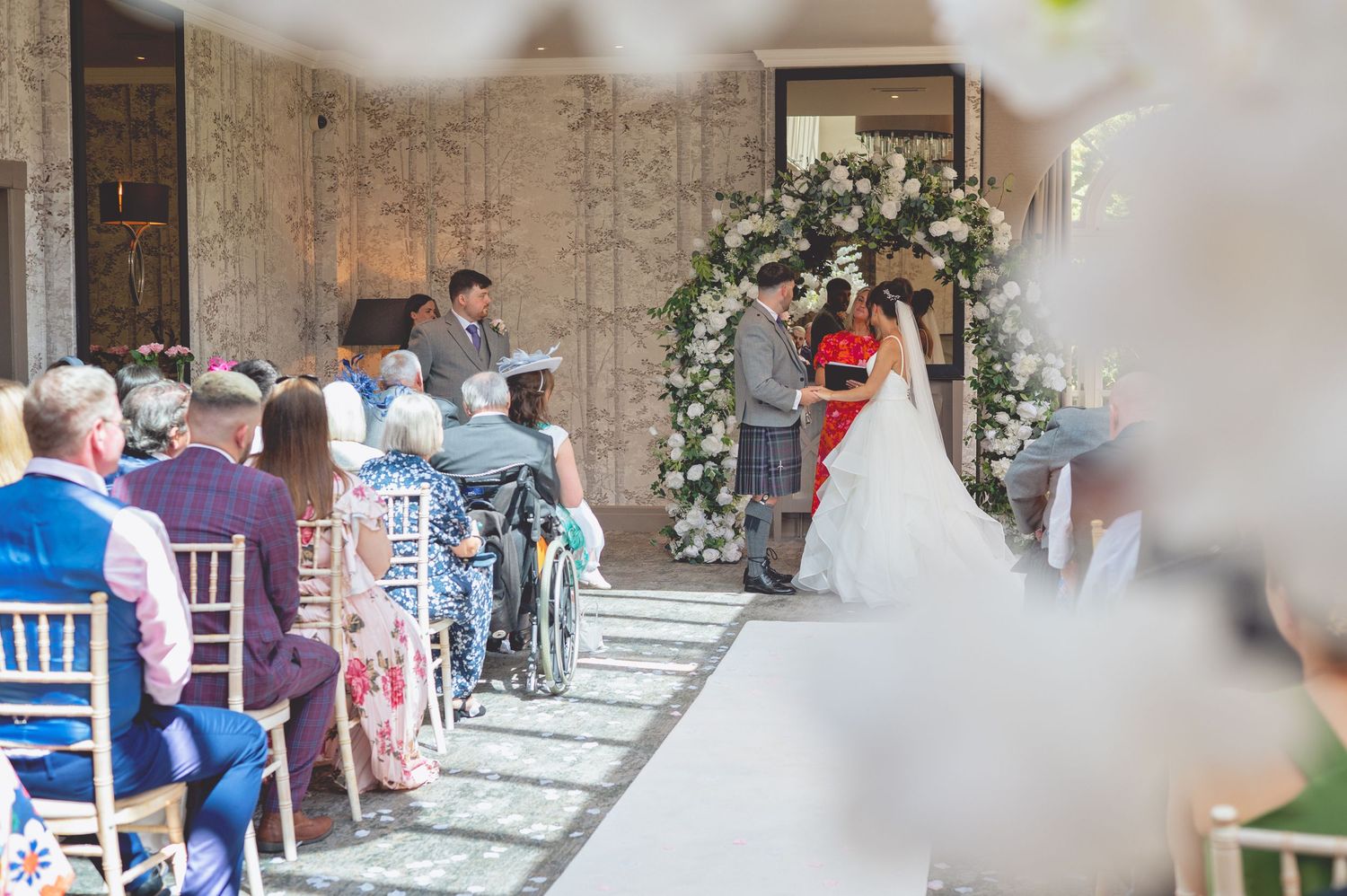 Wedding reception venue with decorated tables and chairs set up for dining celebration.
