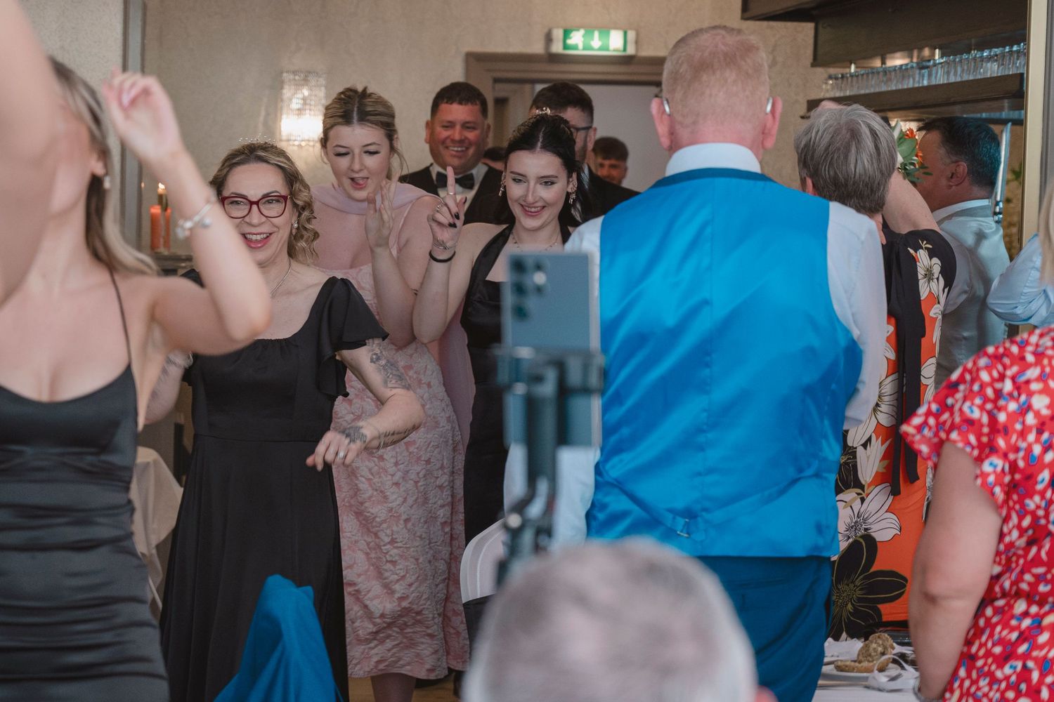 Guests dancing and celebrating at an elegant indoor wedding reception in a decorated venue.