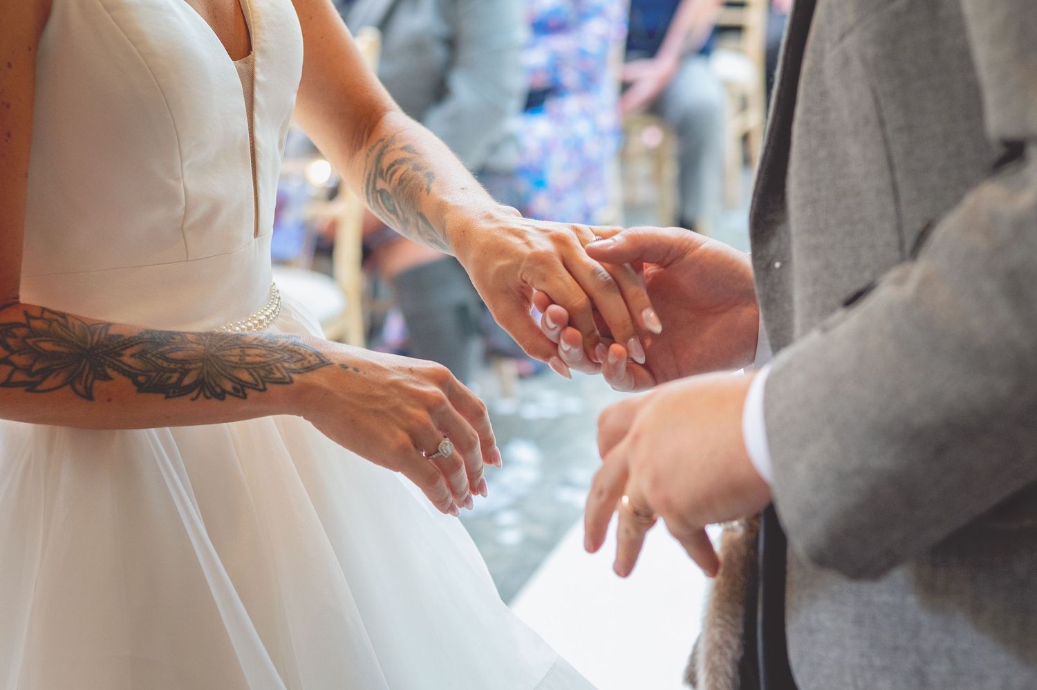Close-up of hands during a wedding ring exchange ceremony.