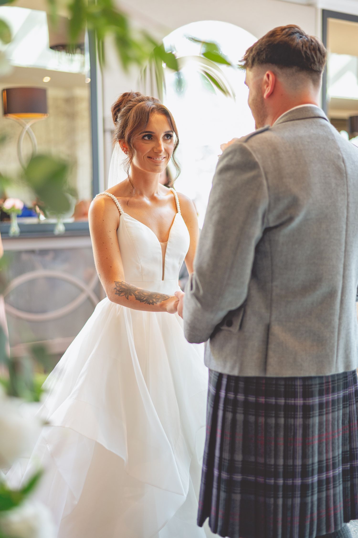 A couple shares an intimate moment during their wedding ceremony with Scottish Highland attire.