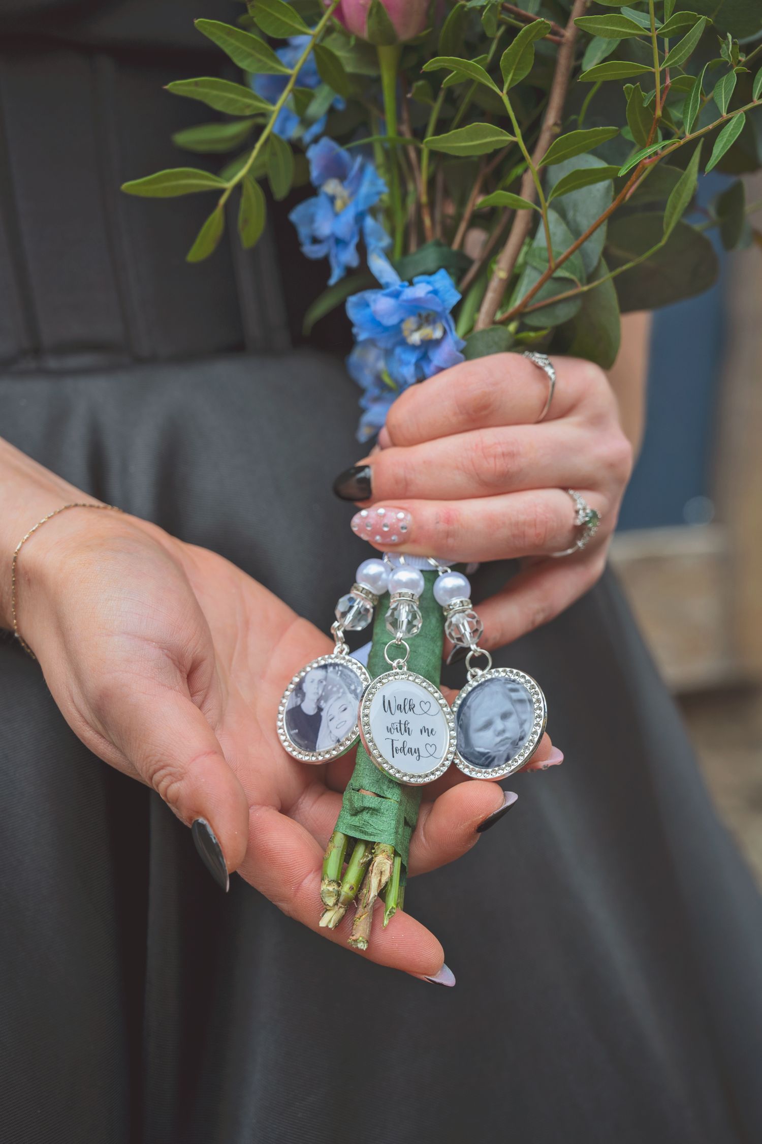 Bride holding bouquet with memorial photo charms reading walk with me today at wedding.