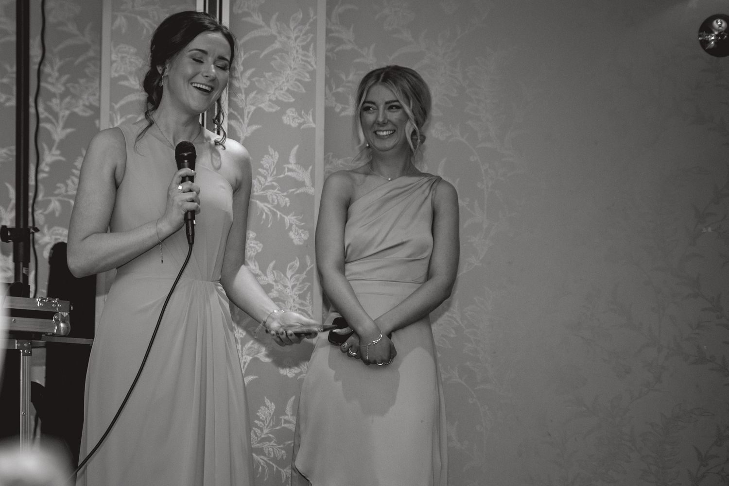 Black and white photo of wedding party members sharing emotional moments during speeches.