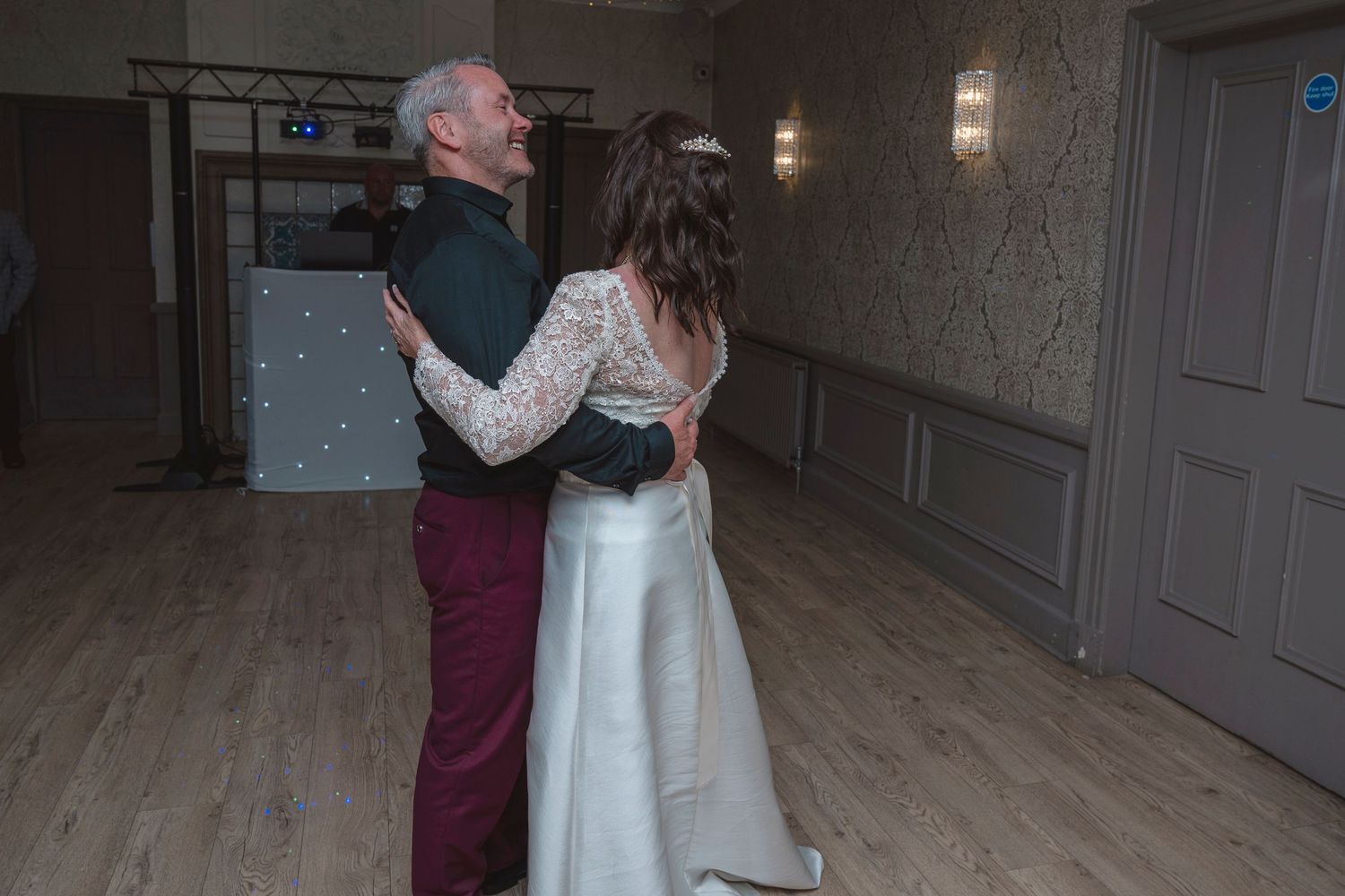 Bride and older man sharing a father-daughter dance in an elegant ballroom at a wedding reception.