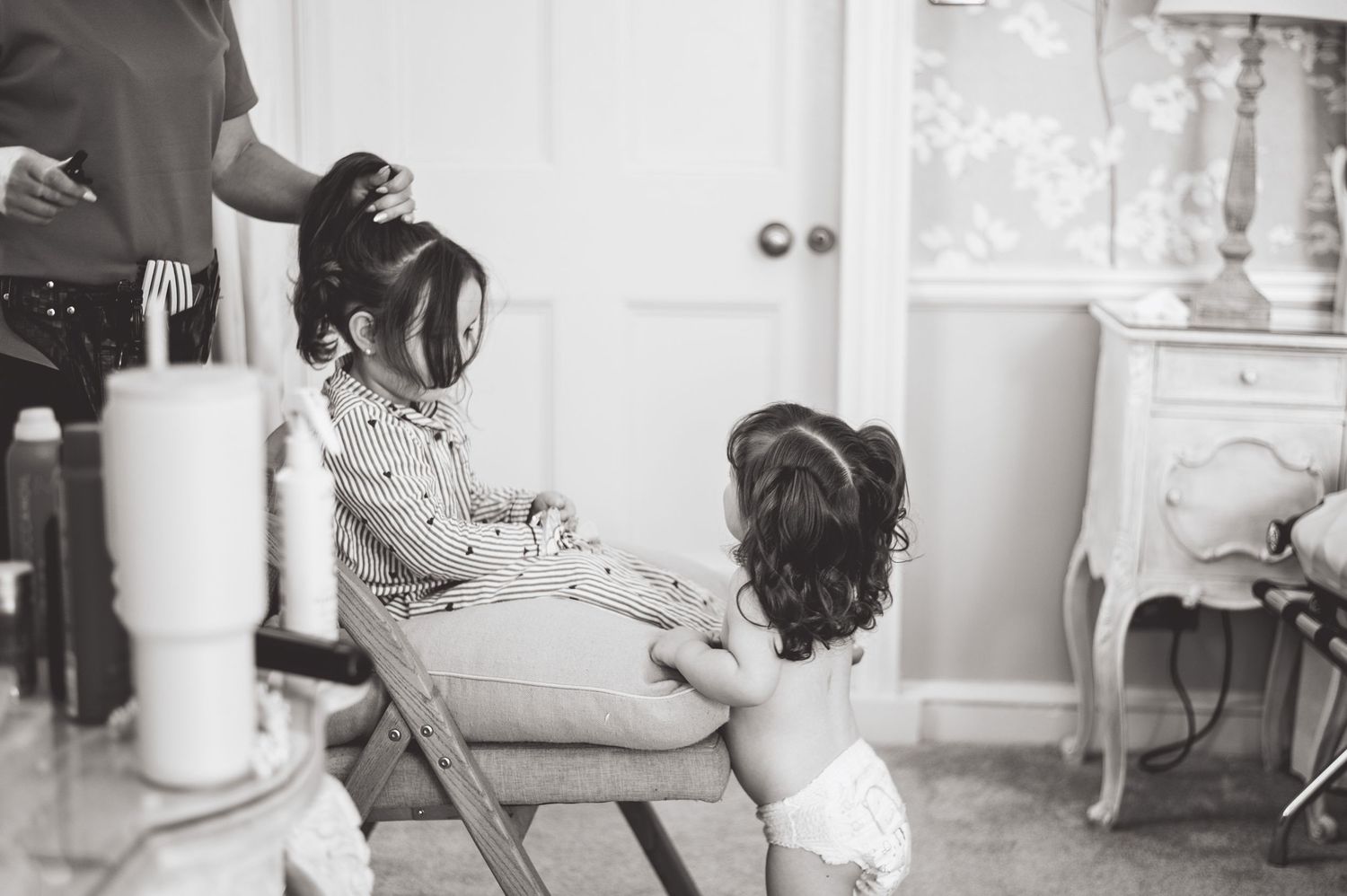 Black and white candid shots of wedding preparations in an indoor setting.