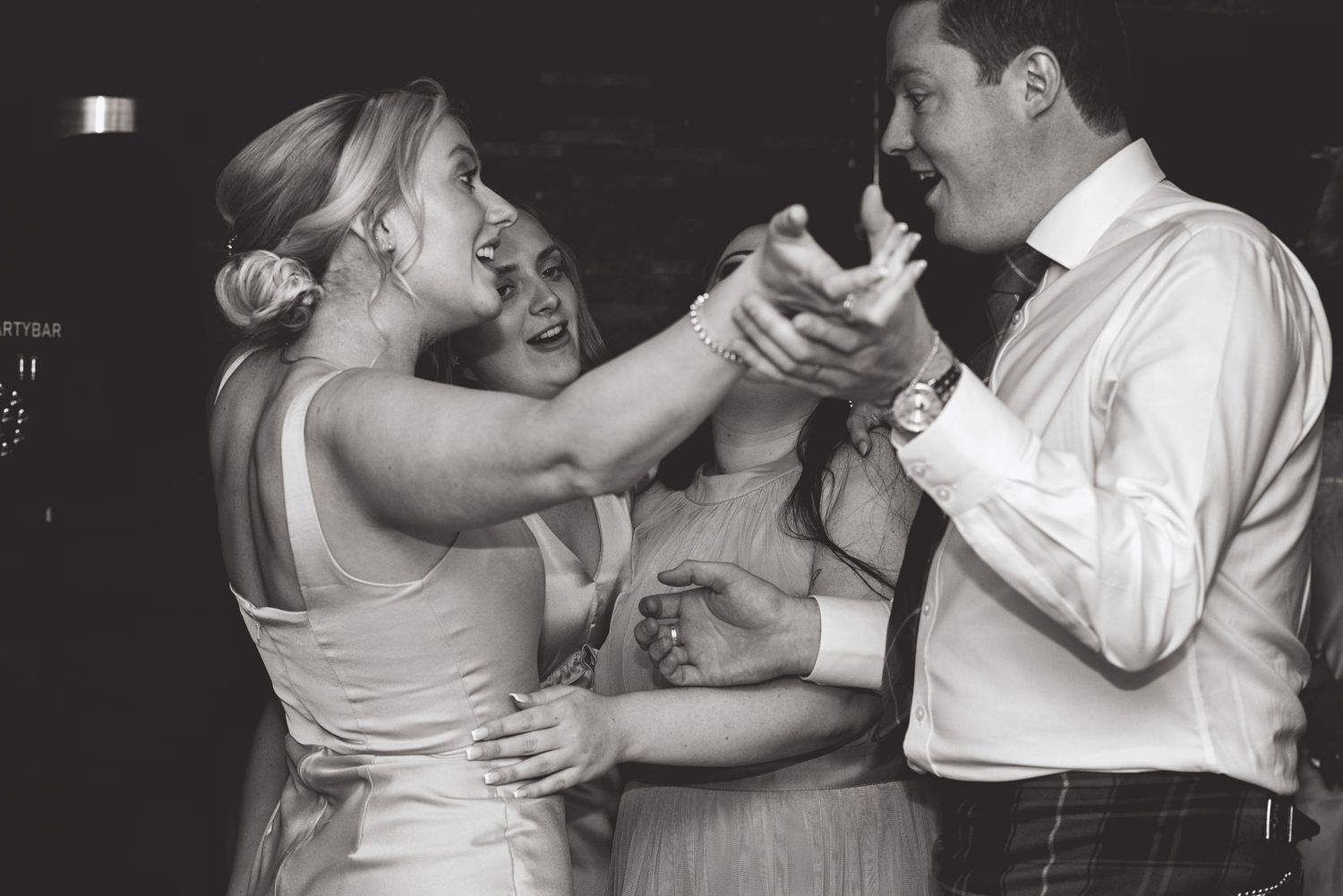 Romantic black and white sequence of dance floor embraces at a wedding celebration.
