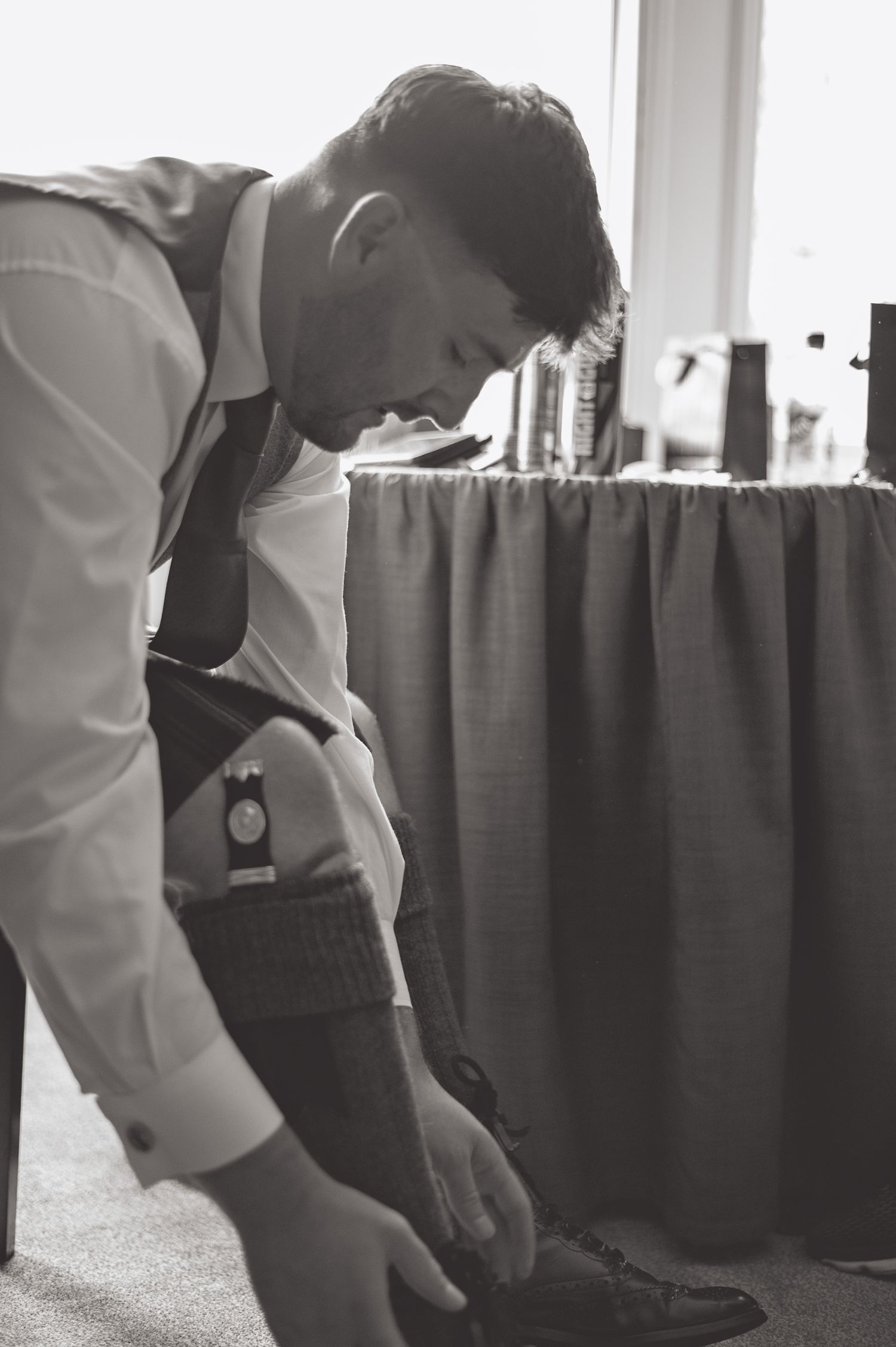 Black and white images of wedding preparation showing formal dressing details.