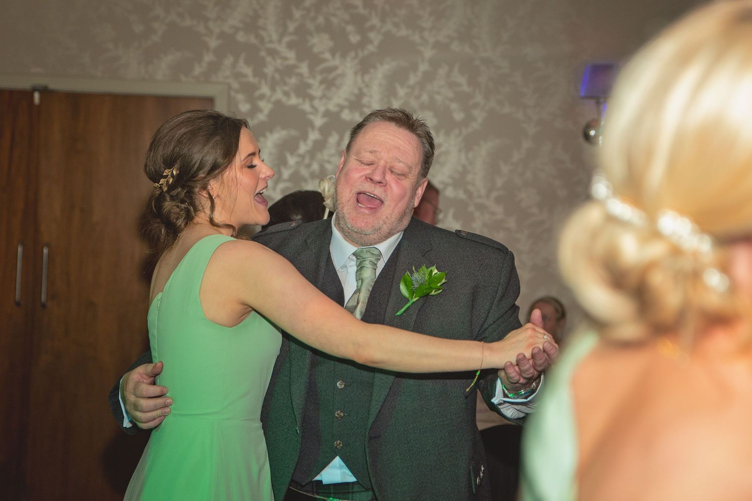 Guests dancing and celebrating at an indoor wedding reception.
