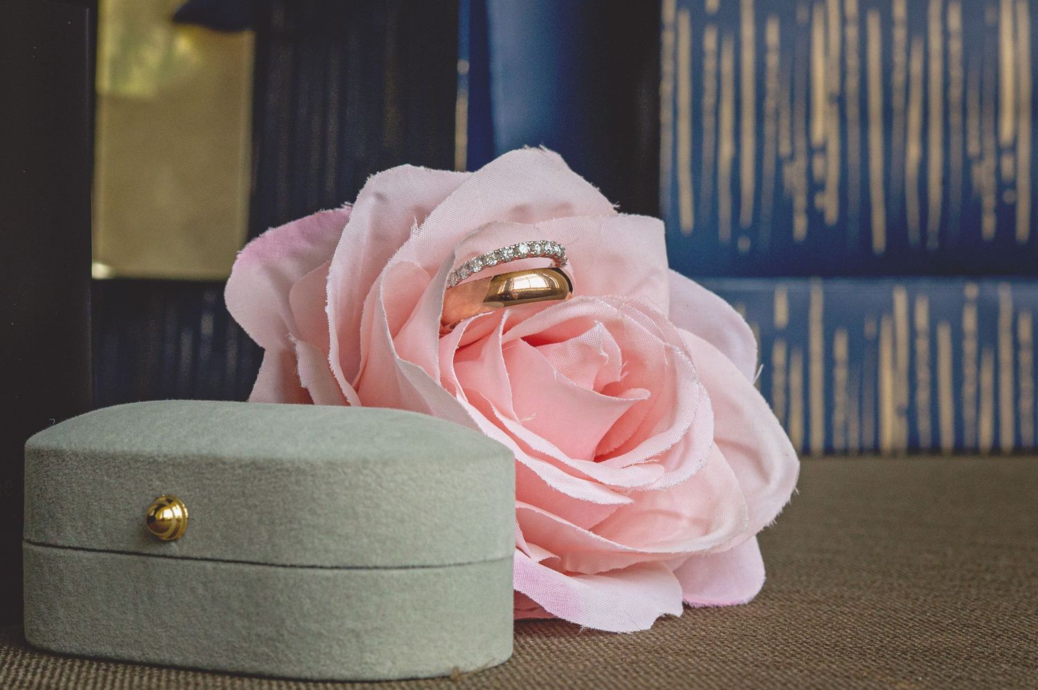 Delicate pink roses arranged next to a light gray wedding cake.