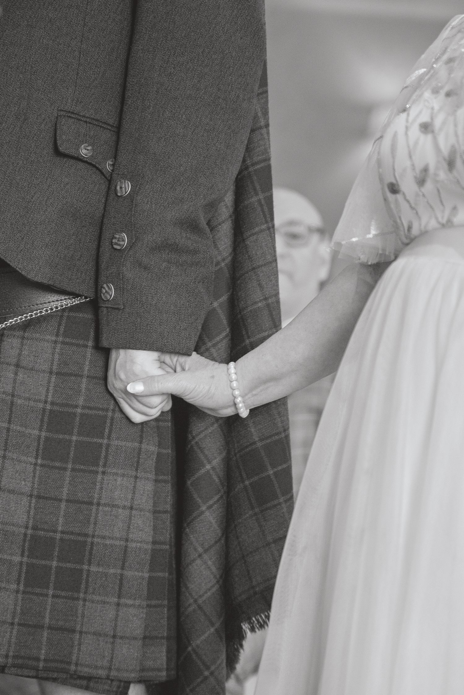 Detail shot of Scottish kilt and white wedding dress fabric textures.