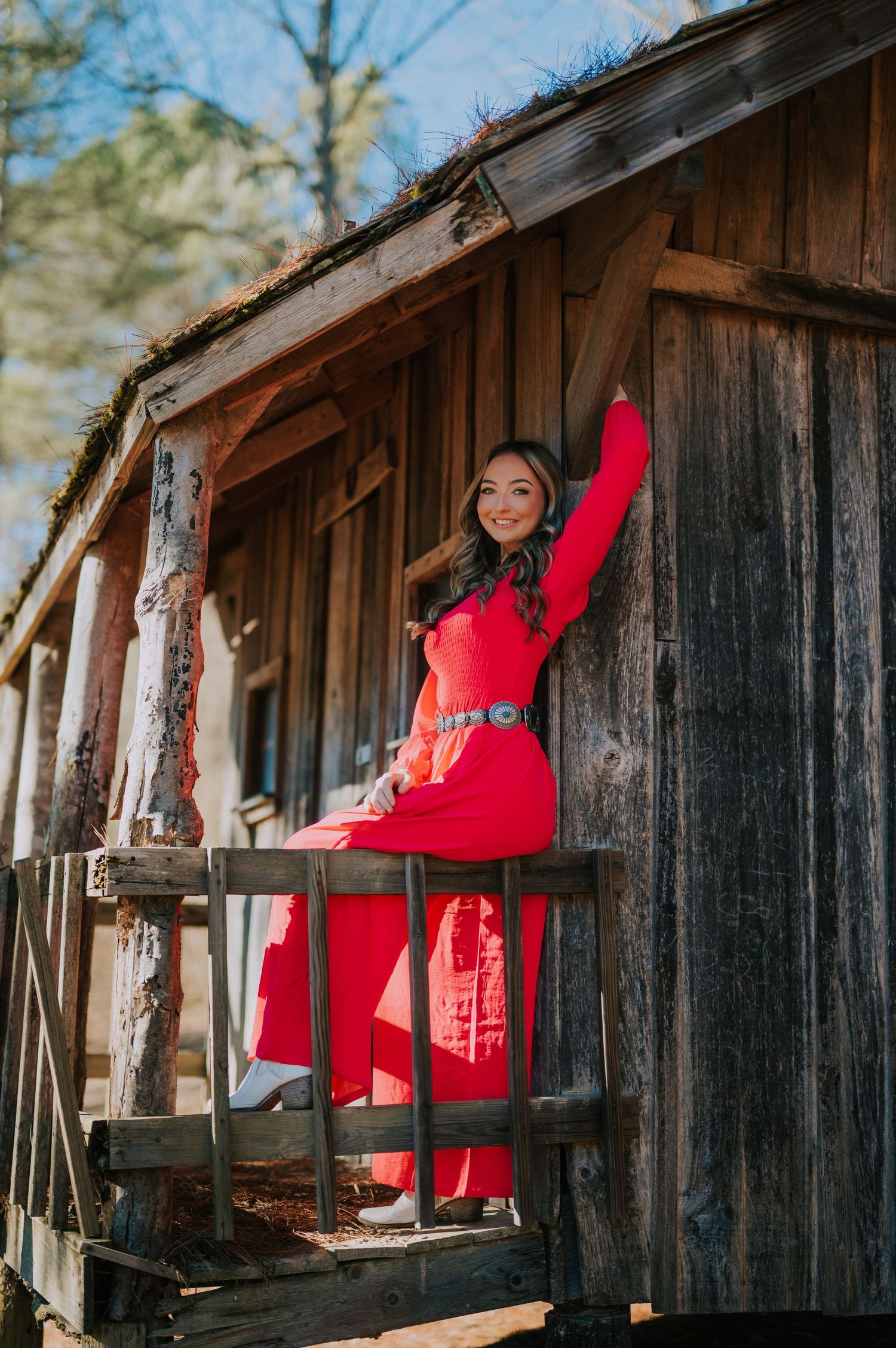 A rustic wooden cabin structure against a bright blue sky.