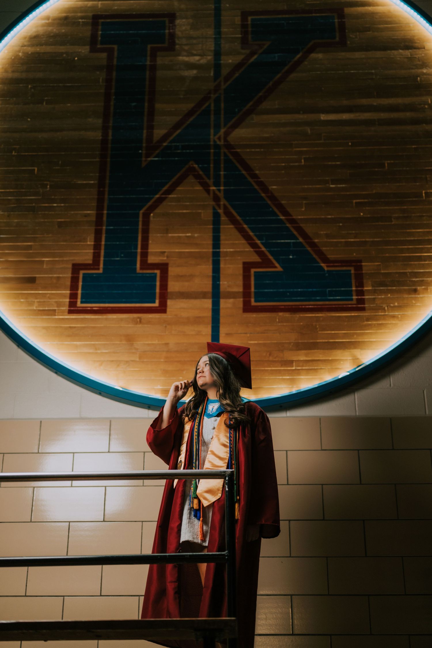 Dramatic lighting illuminates figure against brick wall with large letter signage.