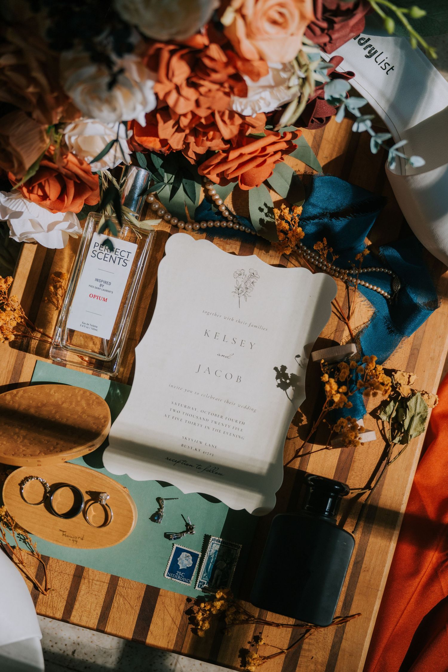 Wedding stationery and orange floral arrangements styled with vintage decorative elements.