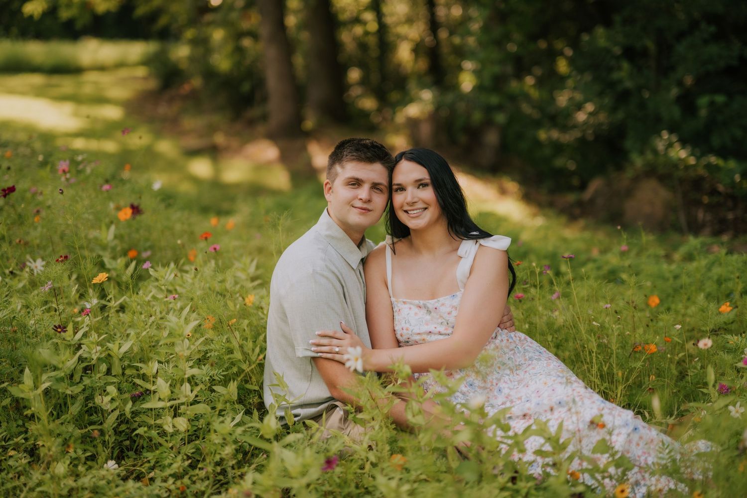 Romantic engagement photos in a lush green outdoor setting.