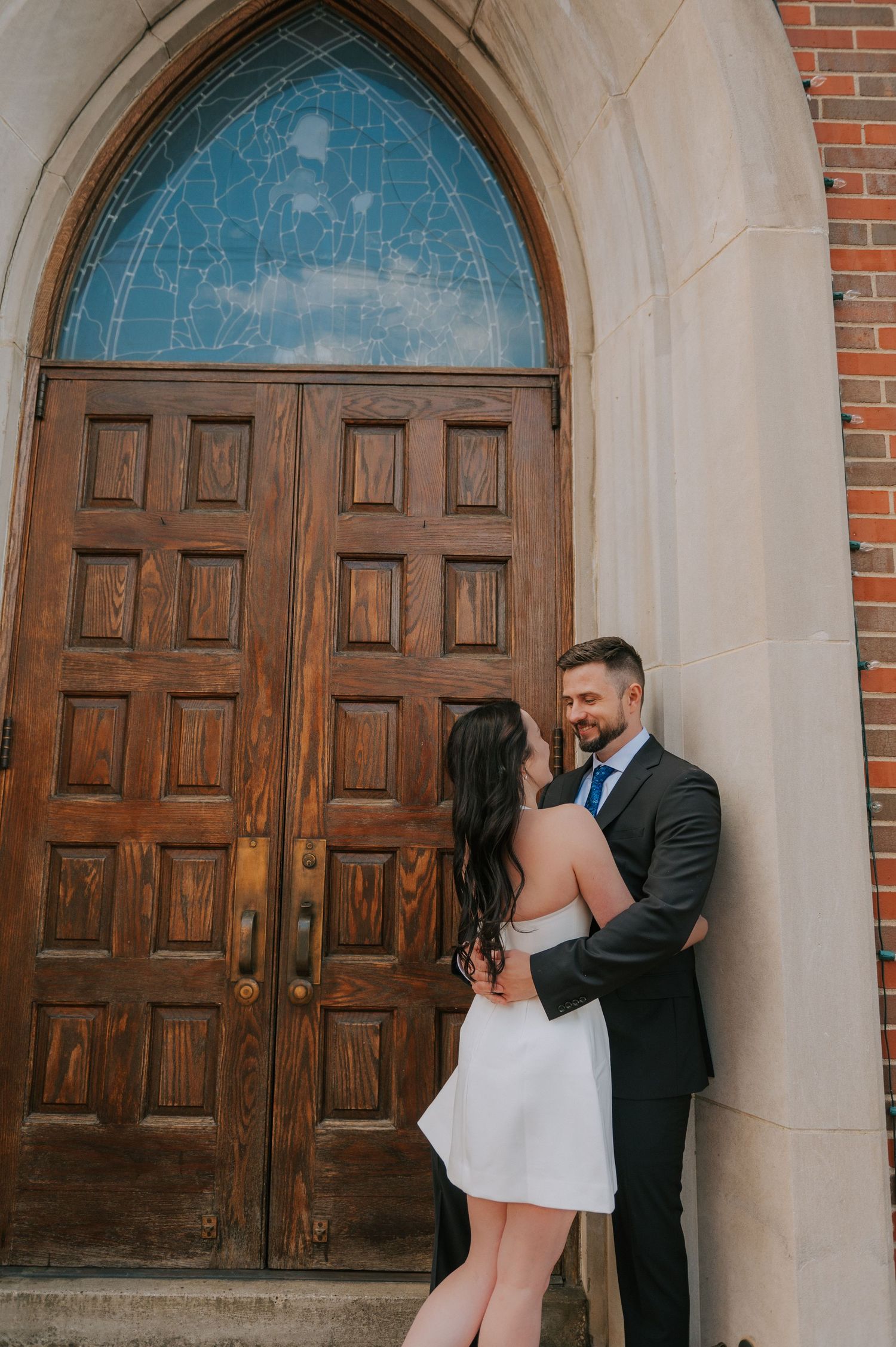 Romantic portraits against wooden church doors and stone archways.
